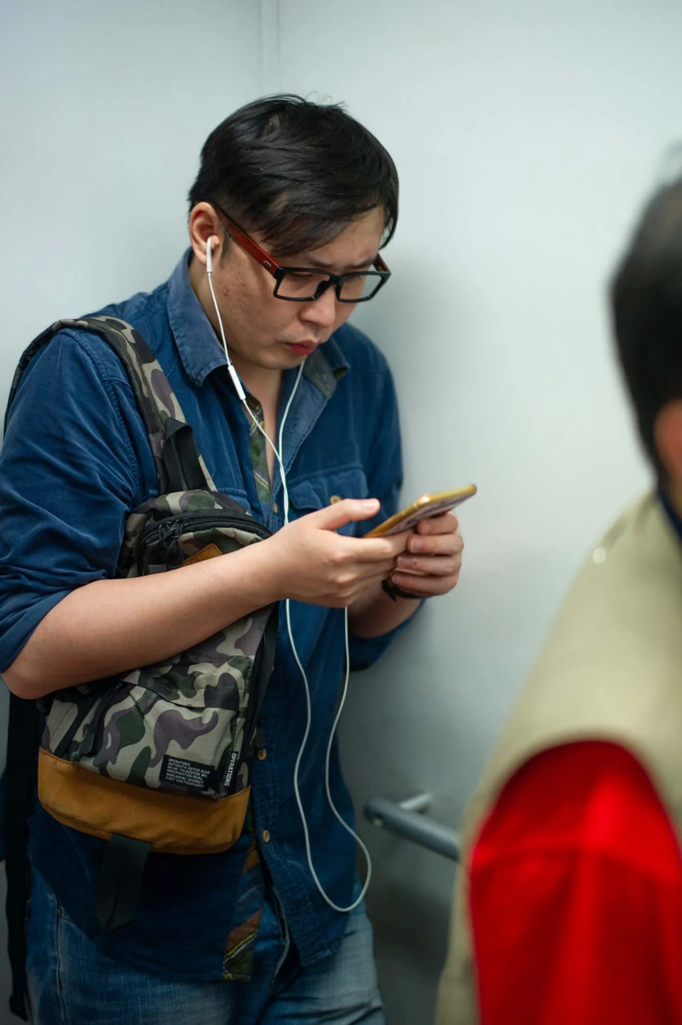 Submerged in thought, passengers in a Shanghai subway car gaze into their smartphones, photographed by Roman Bezjak
