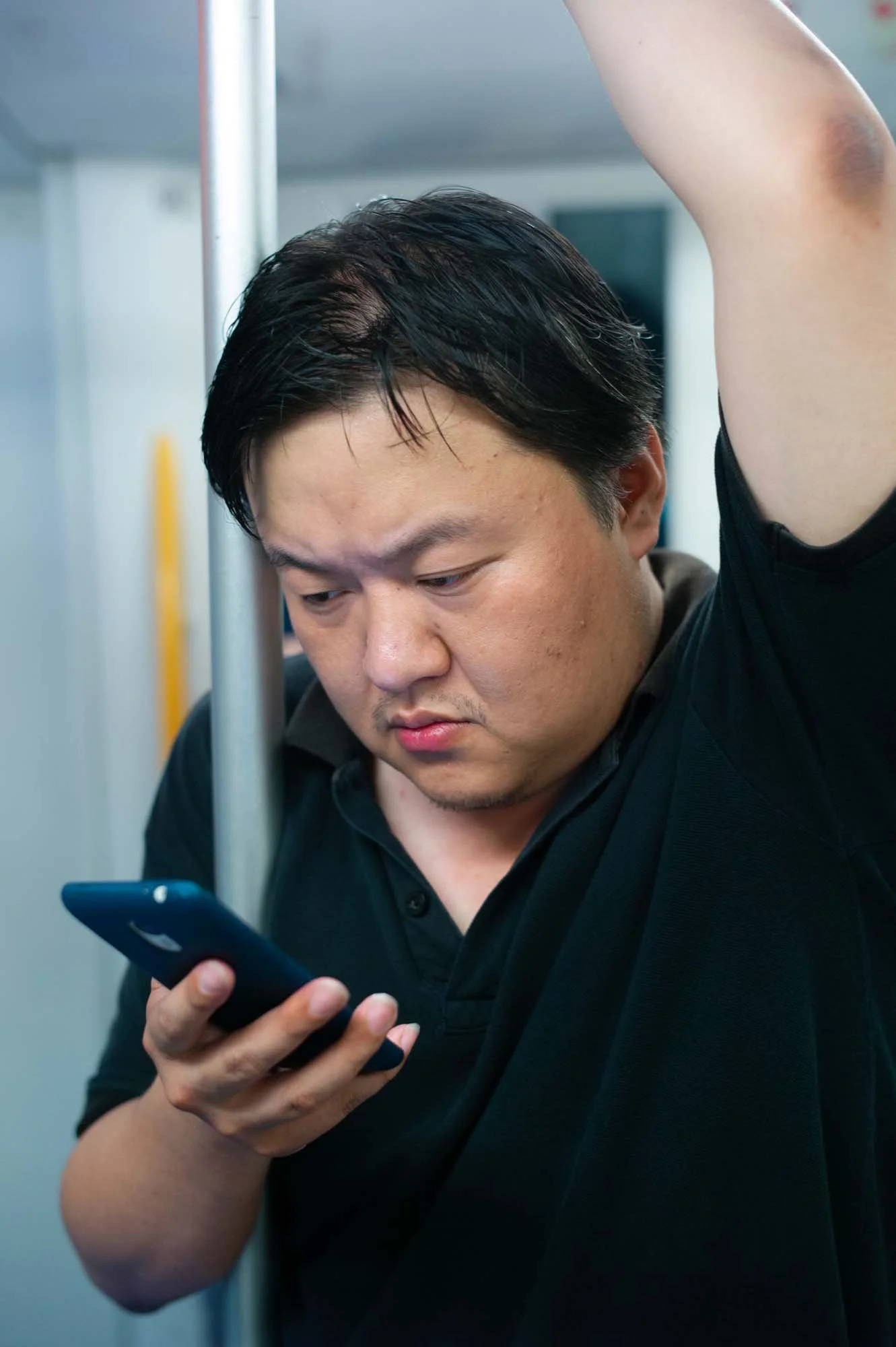 Submerged in thought, passengers in a Shanghai subway car gaze into their smartphones, photographed by Roman Bezjak