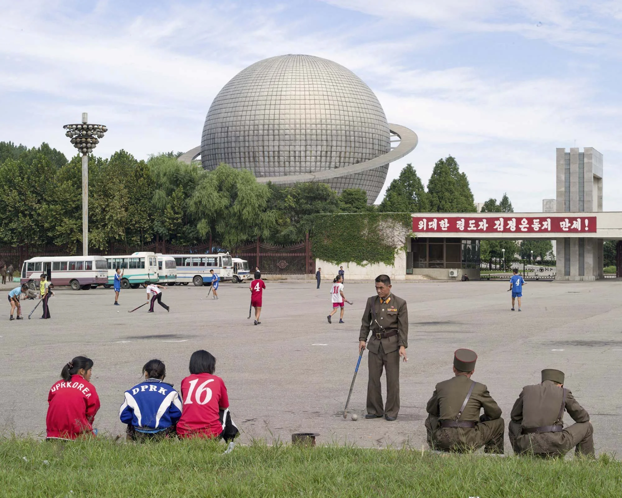 Planetarium auf dem Gelände der Drei-Revolutionen-Ausstellung in Pjöngjang, Nordkorea : Das auffällige Hauptgebäude des Komplexes im Stadtteil Ryonmot-dong ist in Form des Planeten Saturn mit riesigen Ringen gestaltet. Im Vordergrund nutzen Jugendlic