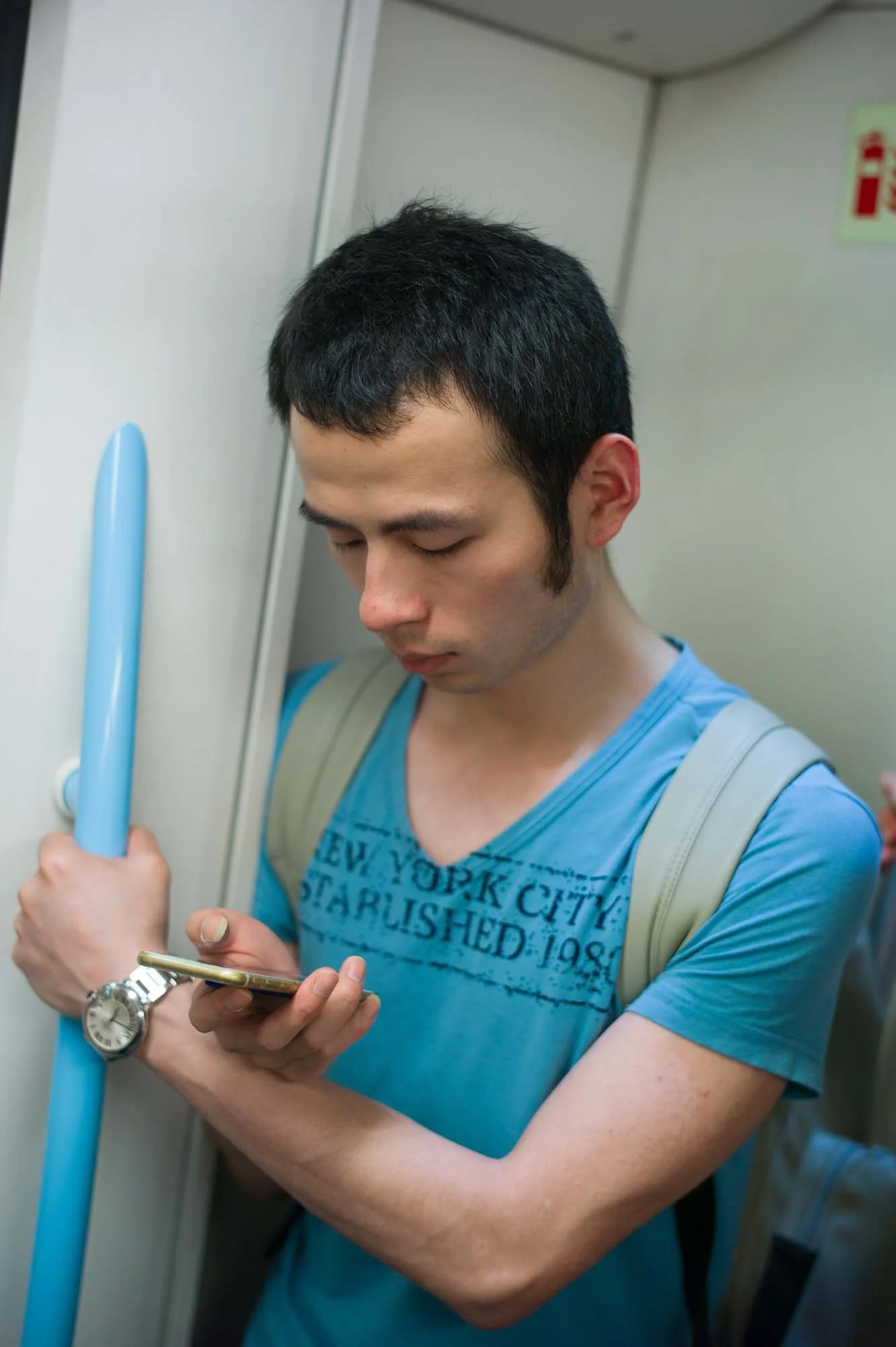 Submerged in thought, passengers in a Shanghai subway car gaze into their smartphones, photographed by Roman Bezjak