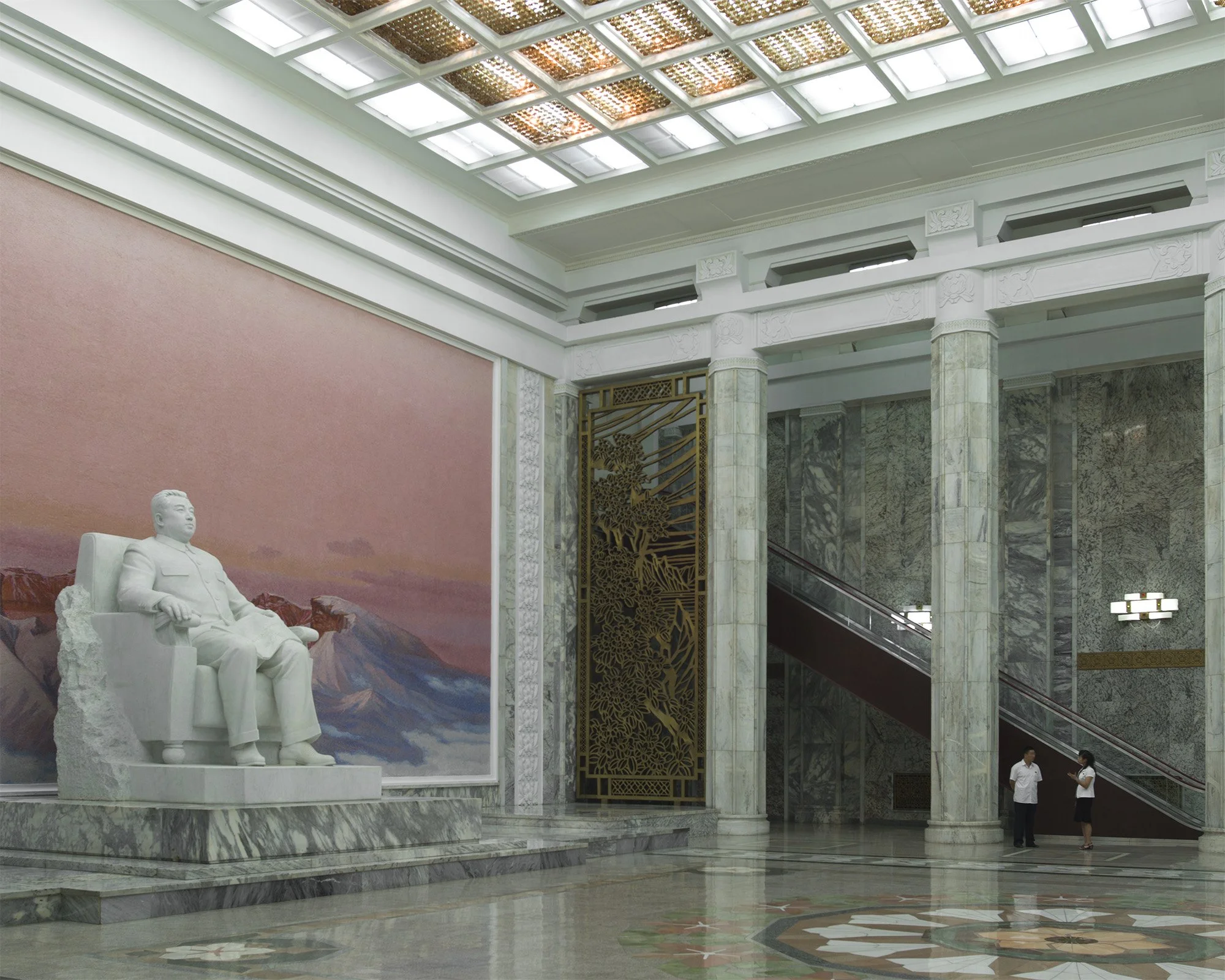monumentale Marmorhalle der zentralen Nationalbibliothek wird von einer weißen Marmorstatue des Staatsgründers Kim Il-sung dominiert. Im Hintergrund erstrecken sich hohe Marmorsäulen, Rolltreppen sowie ein großflächiges Landschaftsgemälde des Paektu-