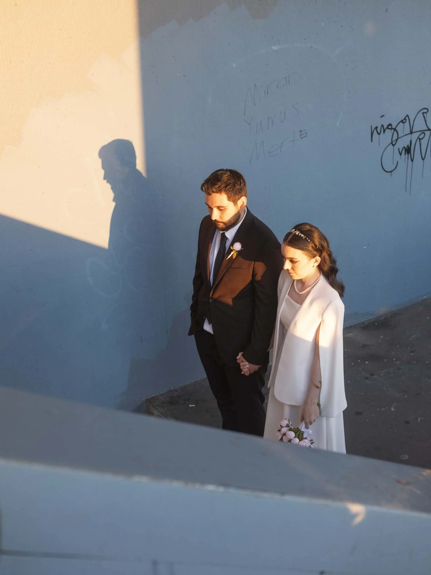 A newlywed couple under the Galata Bridge in Istanbul captured in a documentary photography style by Roman Bezjak
