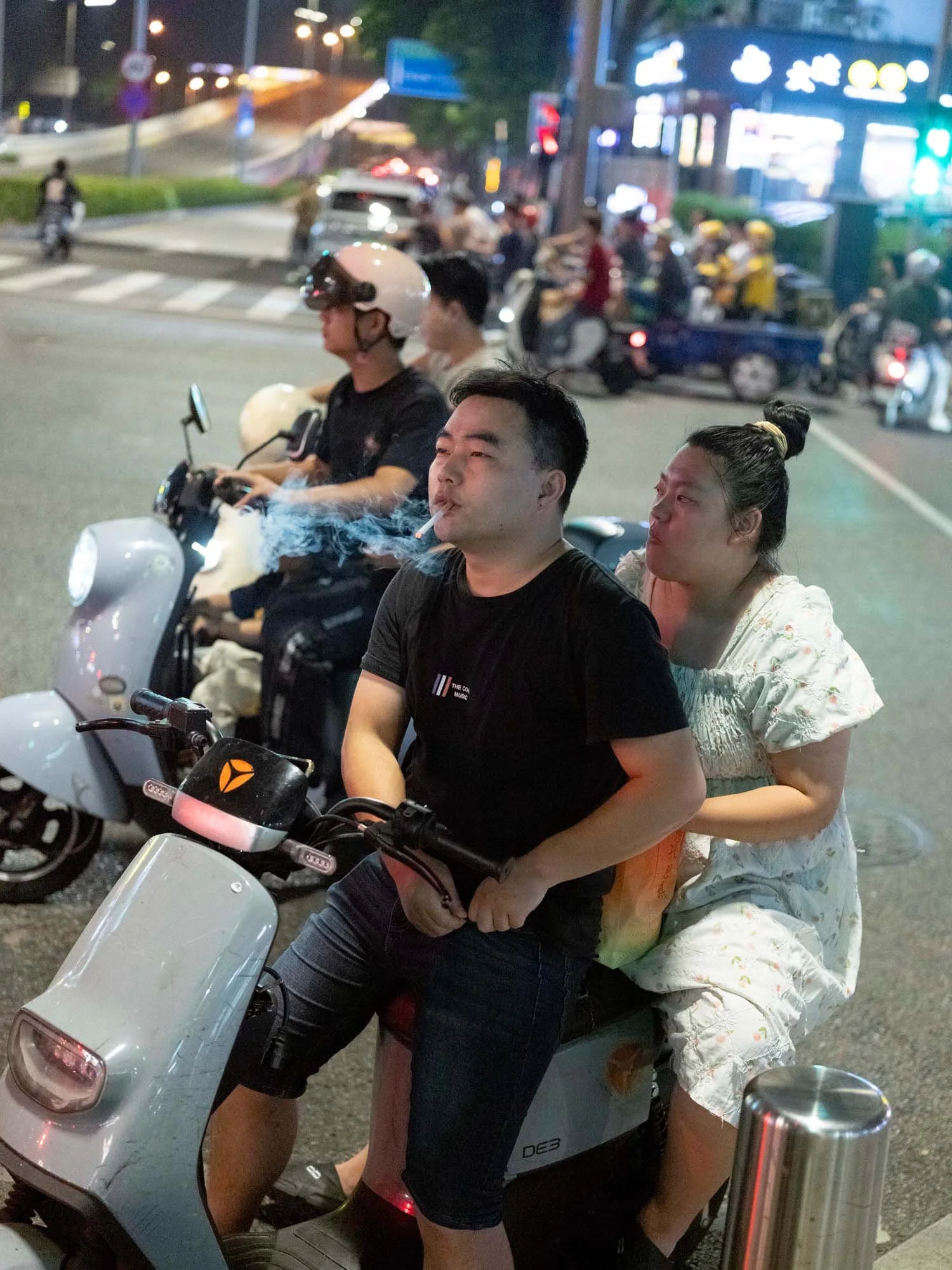 Documentary photograph by Roman Bezjak highlighting Shenzhen as a global leader in e-mobility, showing residents, families, and delivery workers navigating the city on electric scooters.