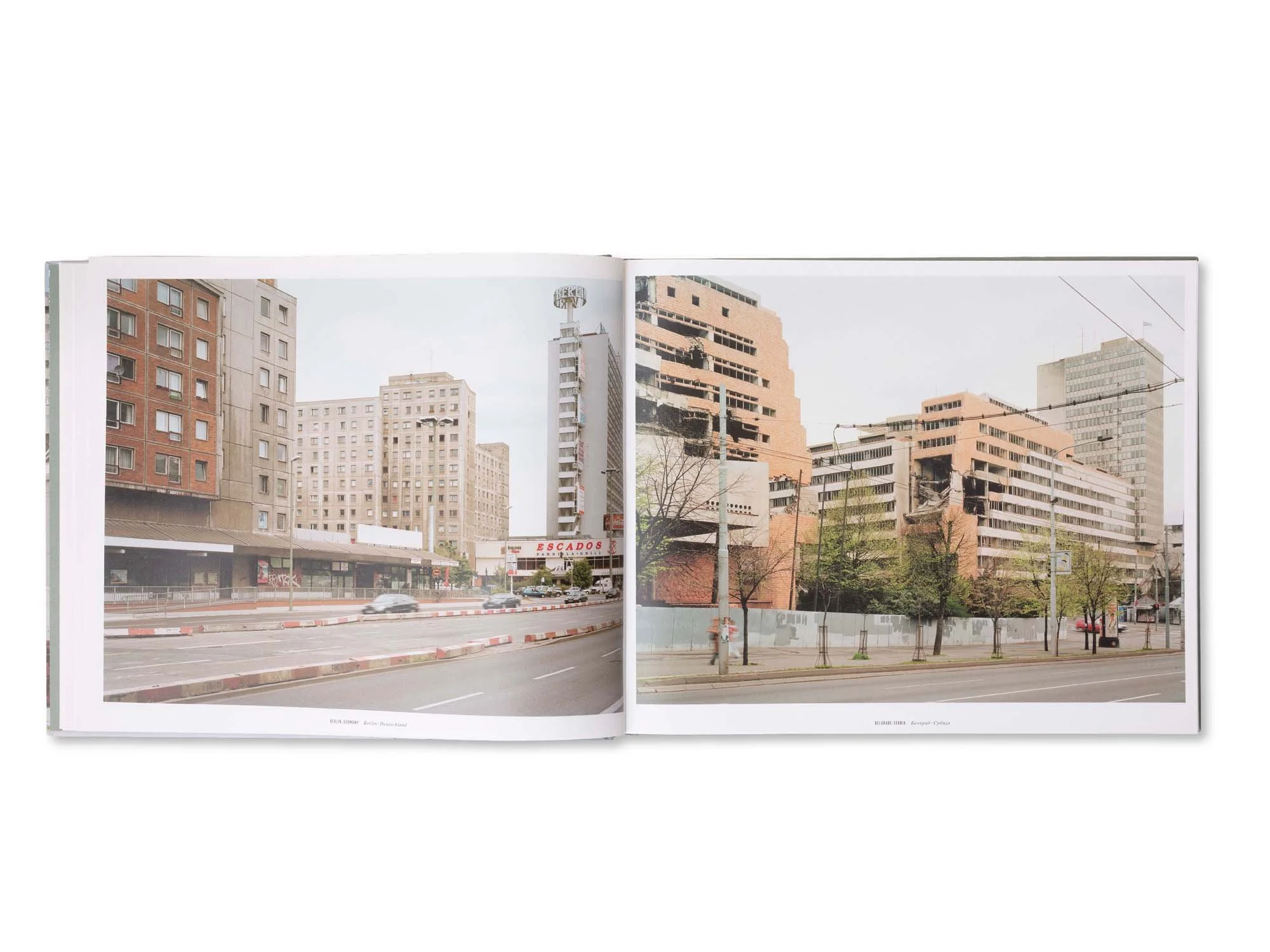 Zwei offene Bücher mit Fotografien von städtischen Gebäuden und Straßen, eine Szene zeigt moderne Hochhäuser, eine andere zerstörte Gebäude in Berlin.