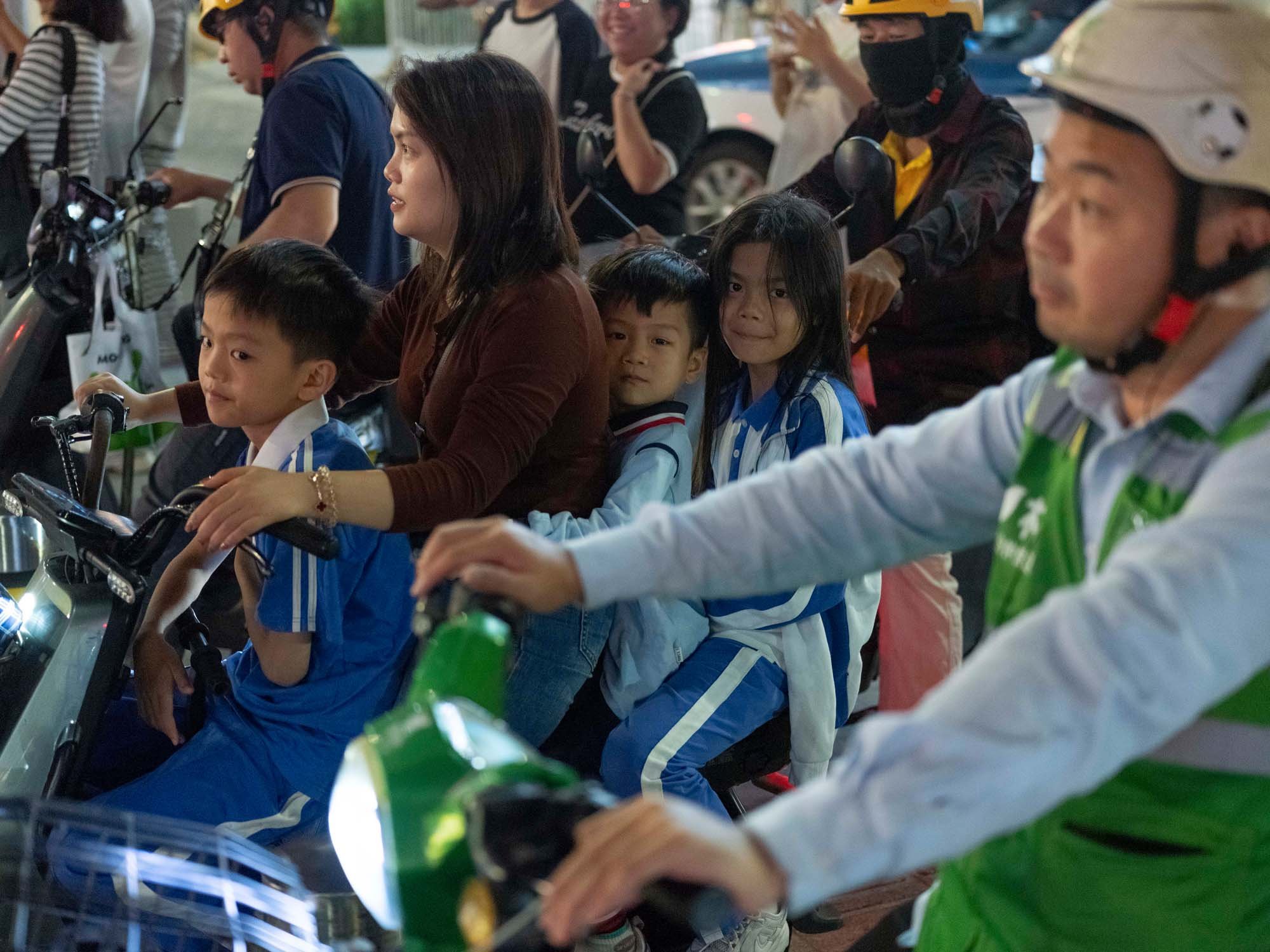 Documentary photograph by Roman Bezjak highlighting Shenzhen as a global leader in e-mobility, showing residents, families, and delivery workers navigating the city on electric scooters.