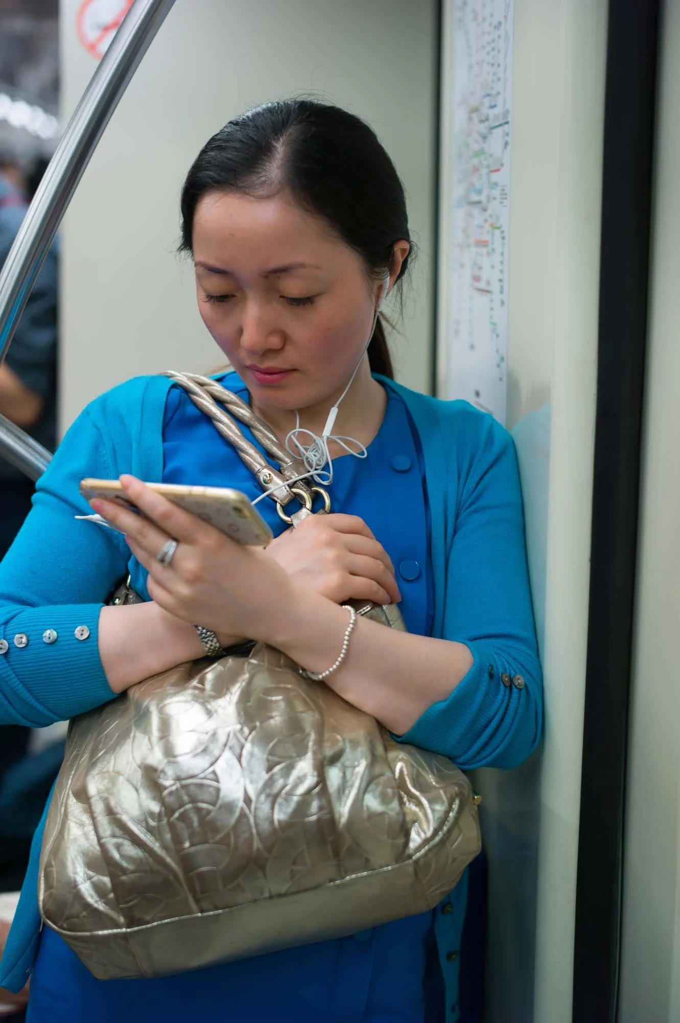 Submerged in thought, passengers in a Shanghai subway car gaze into their smartphones, photographed by Roman Bezjak