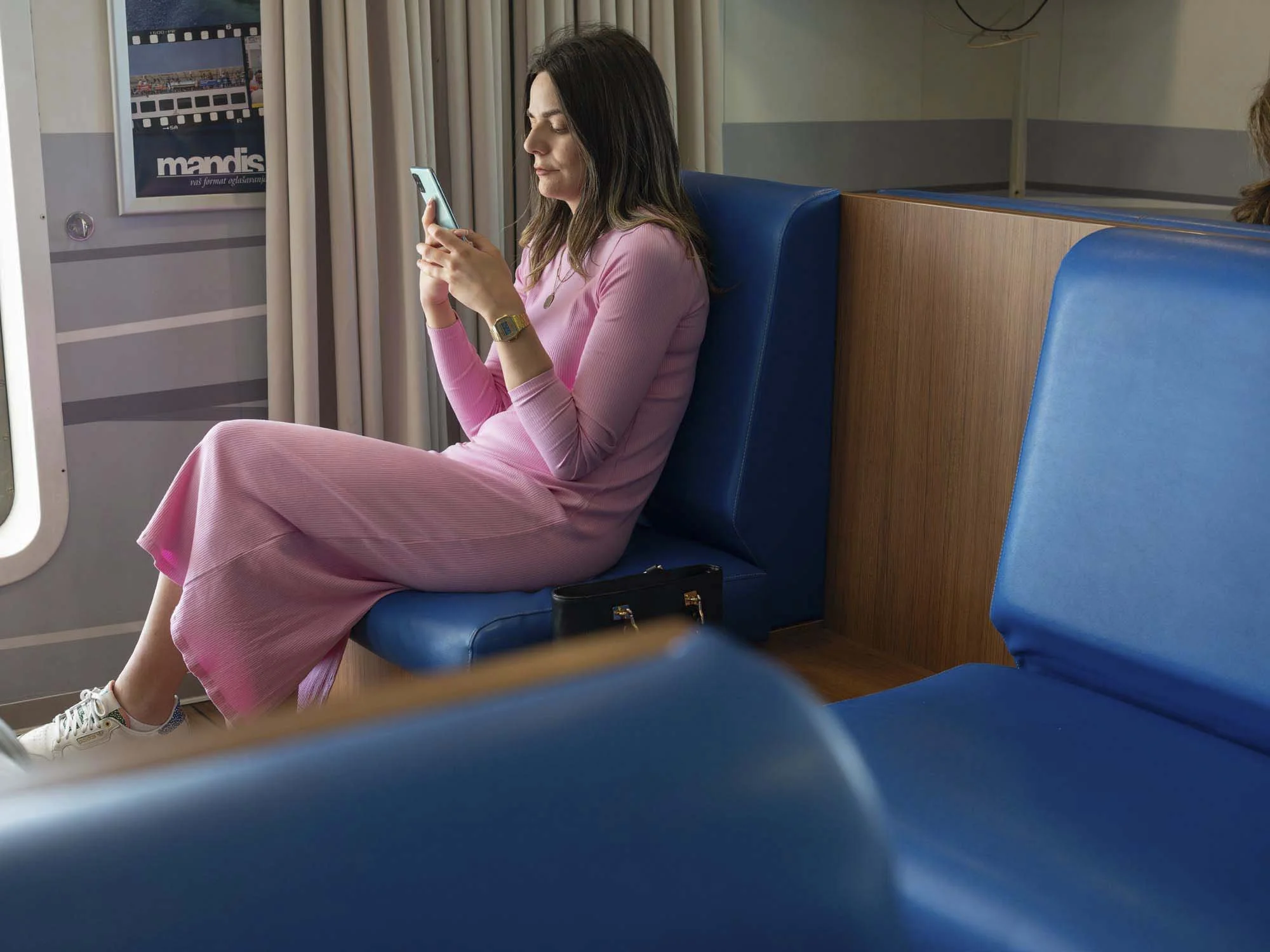Commuters on the early morning ferry from Split to Brač, Croatia, resting and using smartphones on the deck, documentary photography by Roman Bezjak