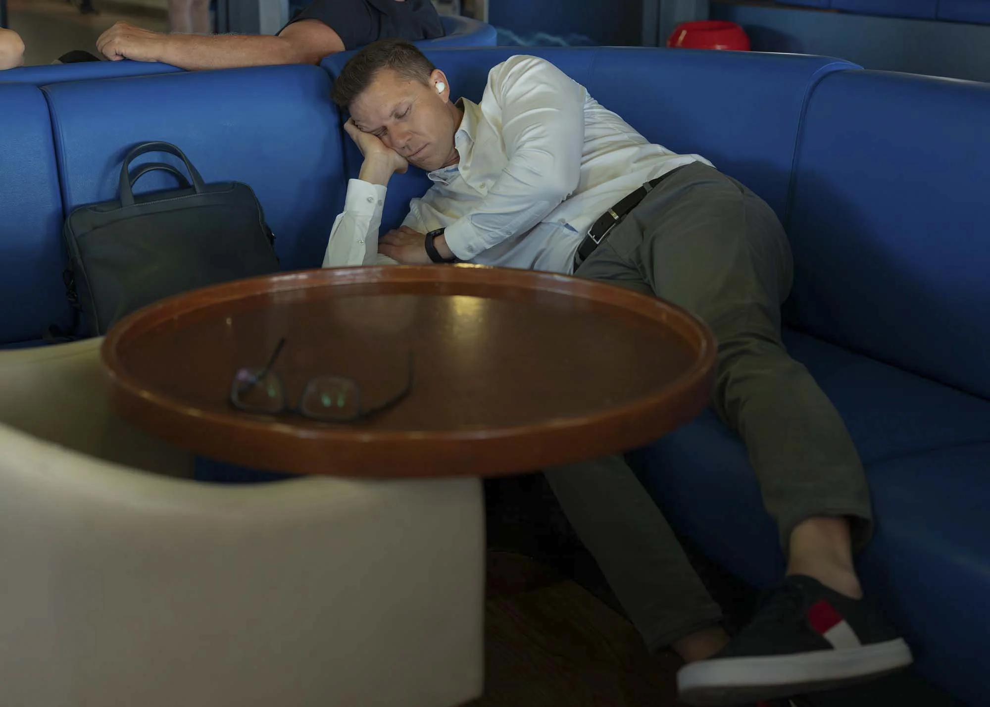Commuters on the early morning ferry from Split to Brač, Croatia, resting and using smartphones on the deck, documentary photography by Roman Bezjak