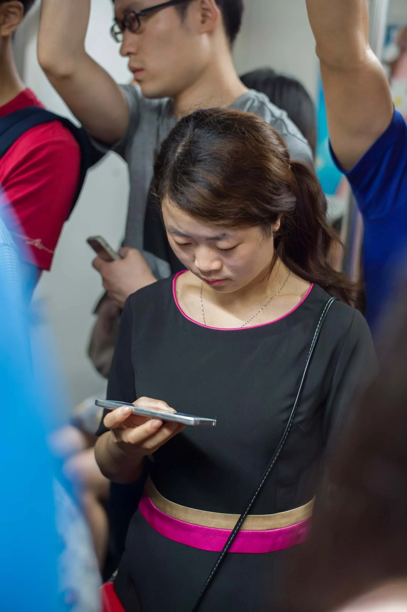Submerged in thought, passengers in a Shanghai subway car gaze into their smartphones, photographed by Roman Bezjak