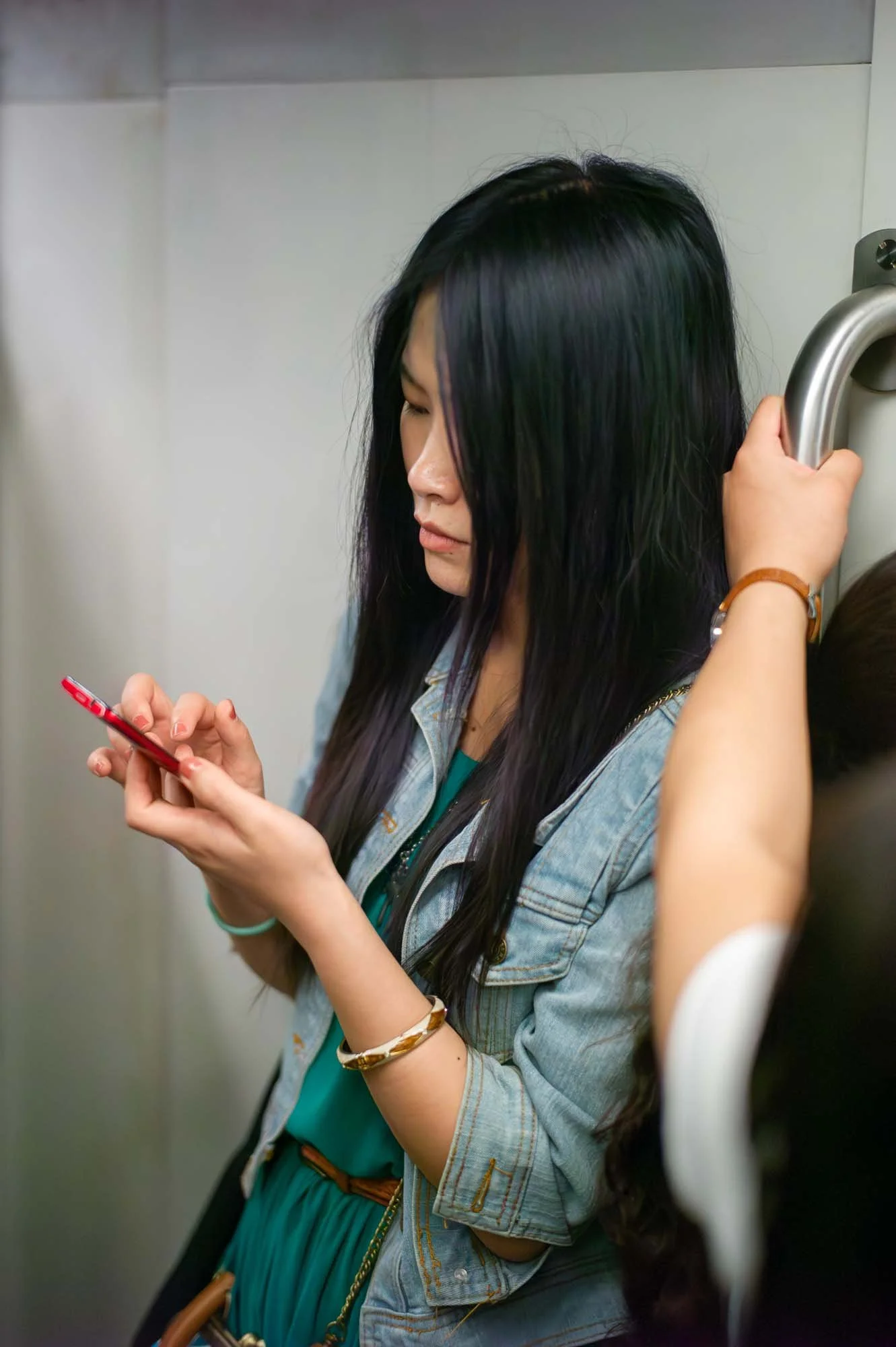 Submerged in thought, passengers in a Shanghai subway car gaze into their smartphones, photographed by Roman Bezjak
