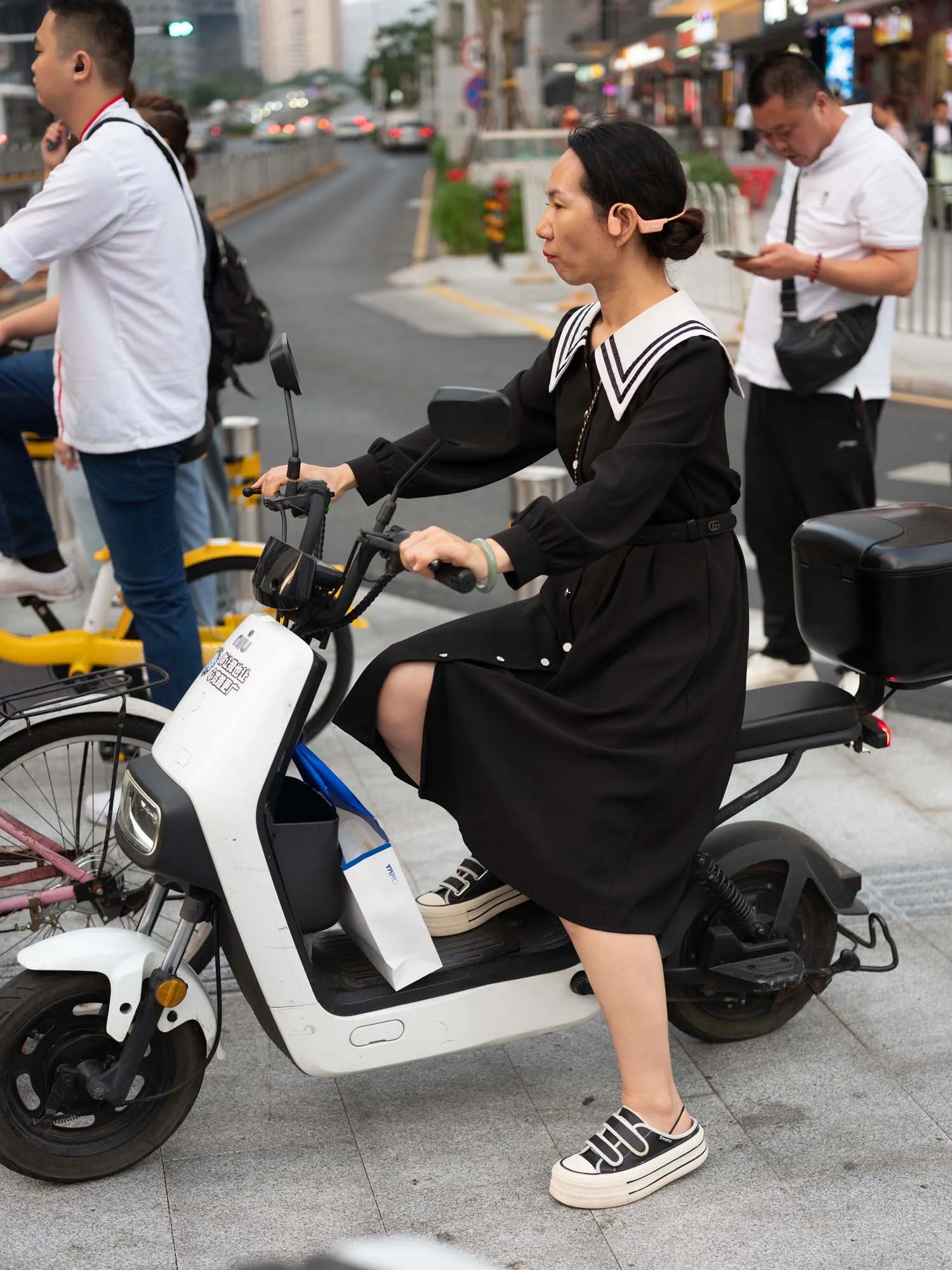 Documentary photograph by Roman Bezjak highlighting Shenzhen as a global leader in e-mobility, showing residents, families, and delivery workers navigating the city on electric scooters.