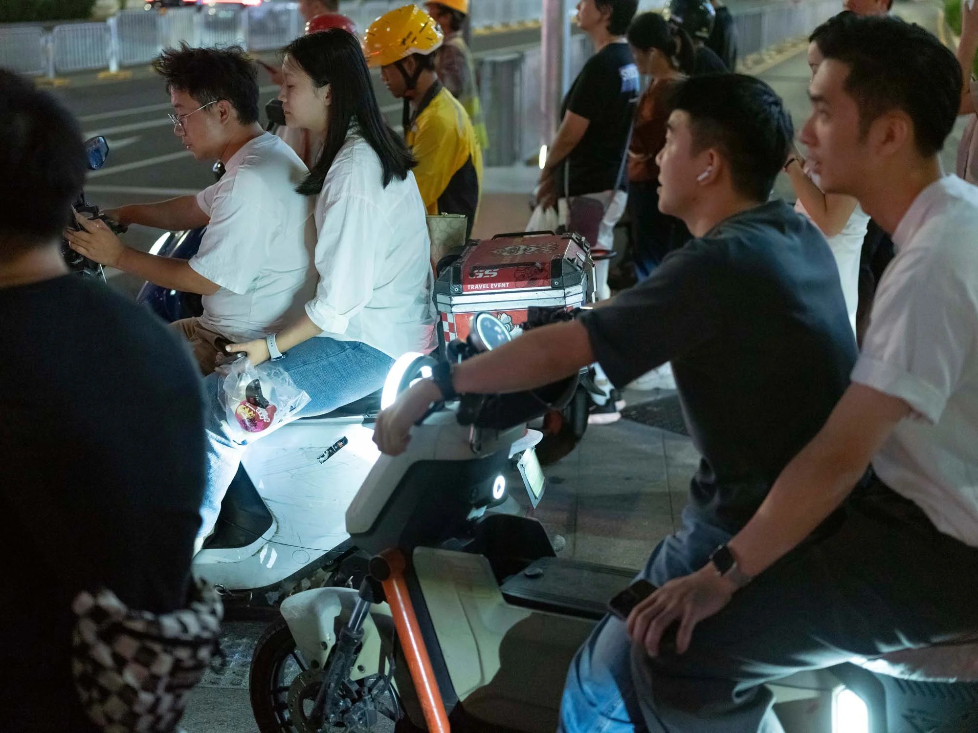 Documentary photograph by Roman Bezjak highlighting Shenzhen as a global leader in e-mobility, showing residents, families, and delivery workers navigating the city on electric scooters.