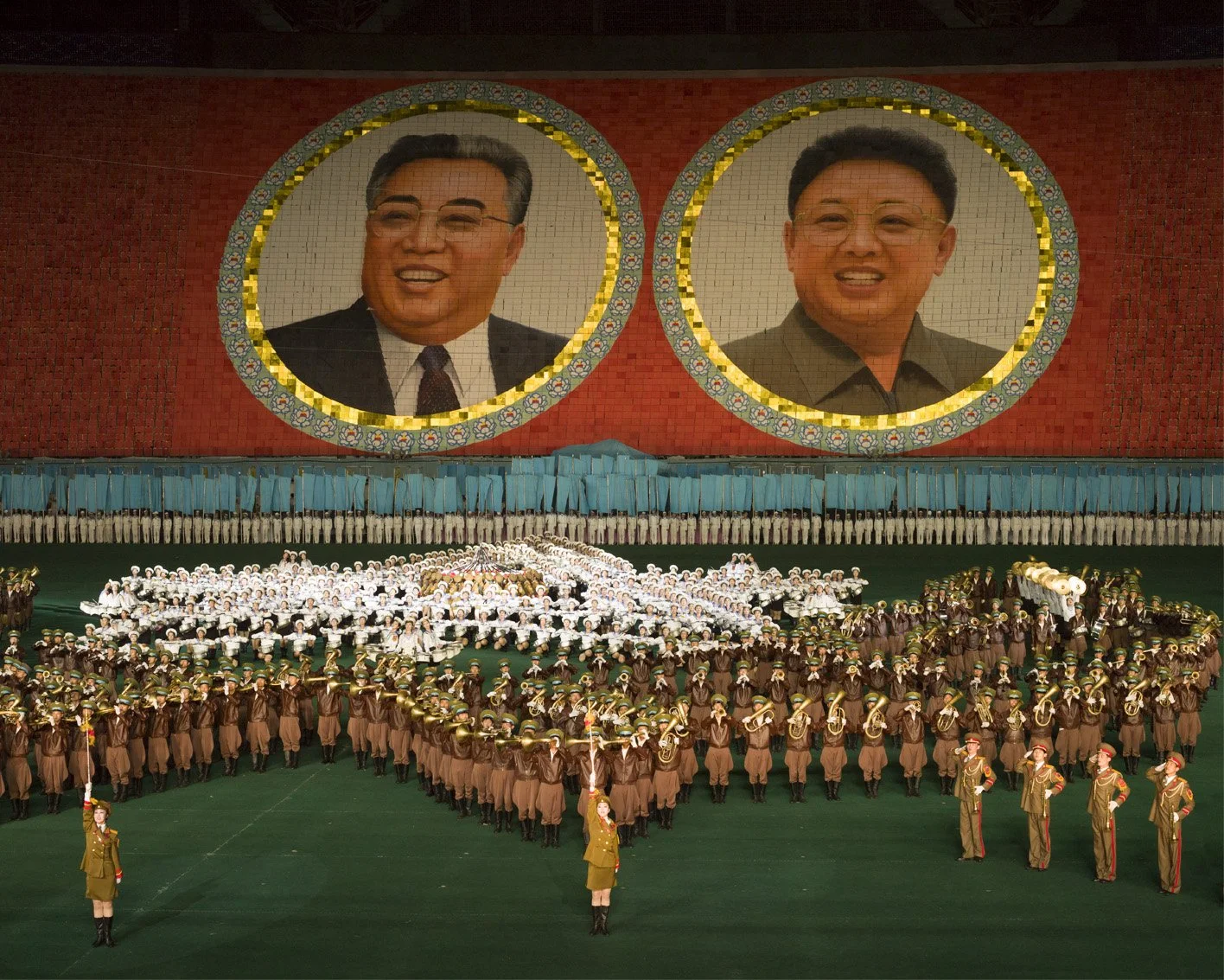 Arirang-Massenspiele im May-Day-Stadion (Rungrado-1.-Mai-Stadion) in Pjöngjang, Nordkorea: Tausende Darsteller bilden eine monumentale Choreografie aus Musik, Tanz, Turnen und synchronisierten Formationen. Im Hintergrund sind die Porträts von Kim Il-