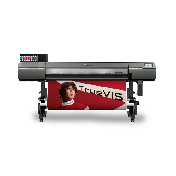 Large-format Roland printer printing a poster featuring a young man in red with the text "TRUEVIS".