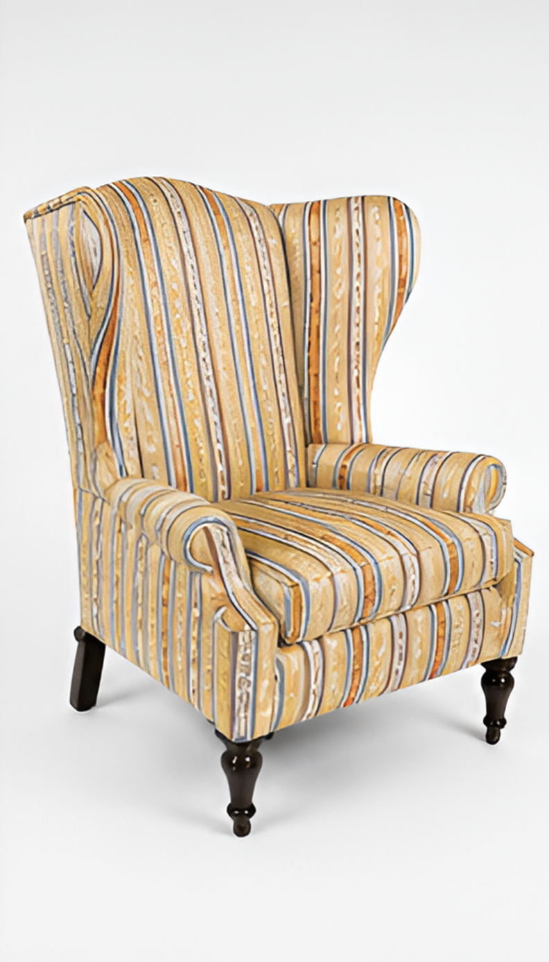 A tall, upholstered wingback armchair with striped yellow, blue, and beige fabric, standing on dark wooden legs against a plain white background.