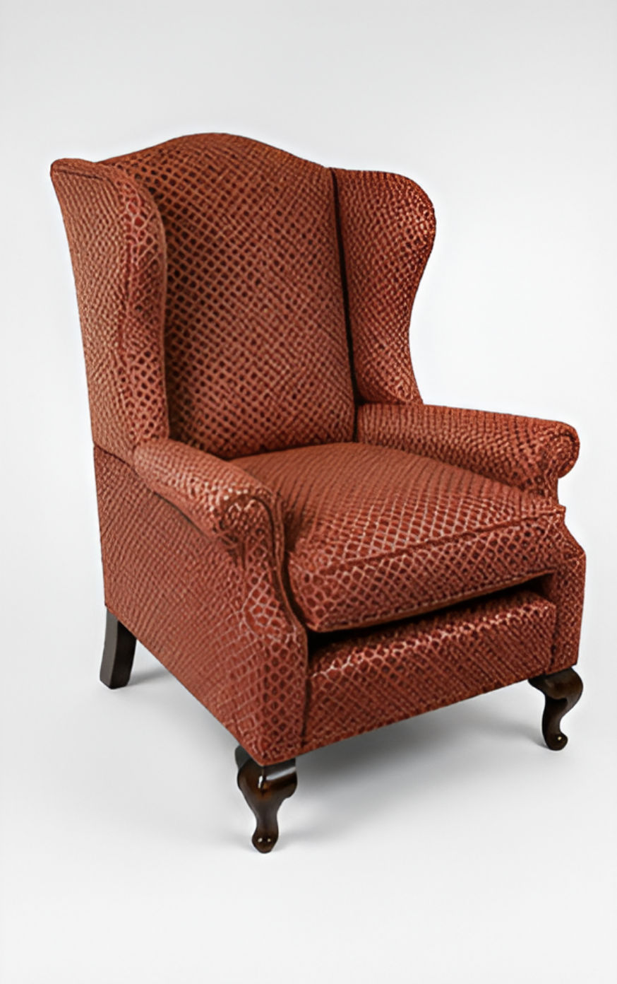 A vintage red wingback armchair with patterned upholstery and dark wooden carved legs on a white background.