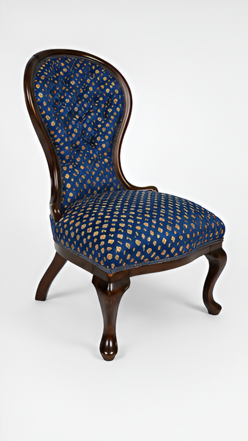 A vintage wooden armchair with a curved backrest, upholstered in dark blue fabric with a gold dotted pattern, against a plain white background.