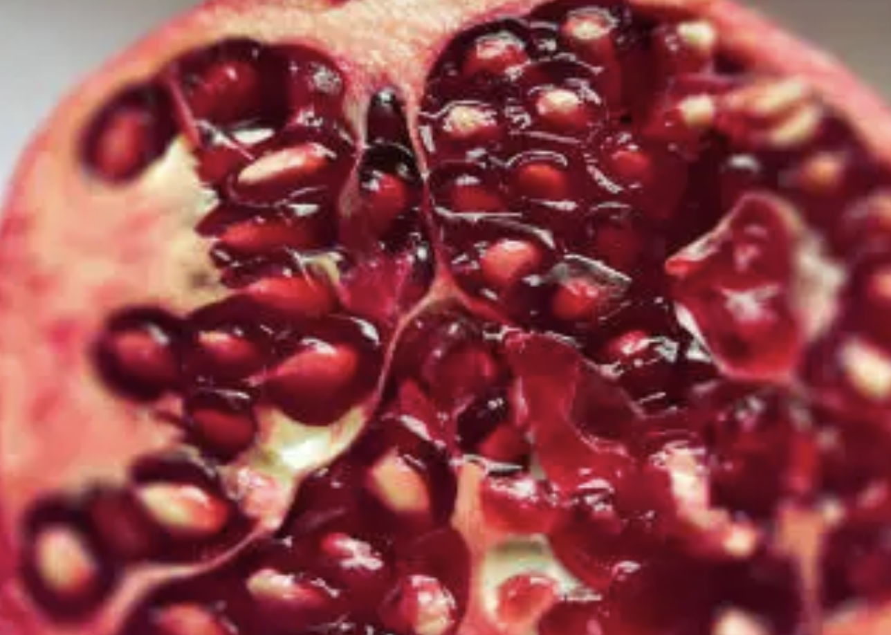 Close-up of a pomegranate cut open to reveal its red seeds.