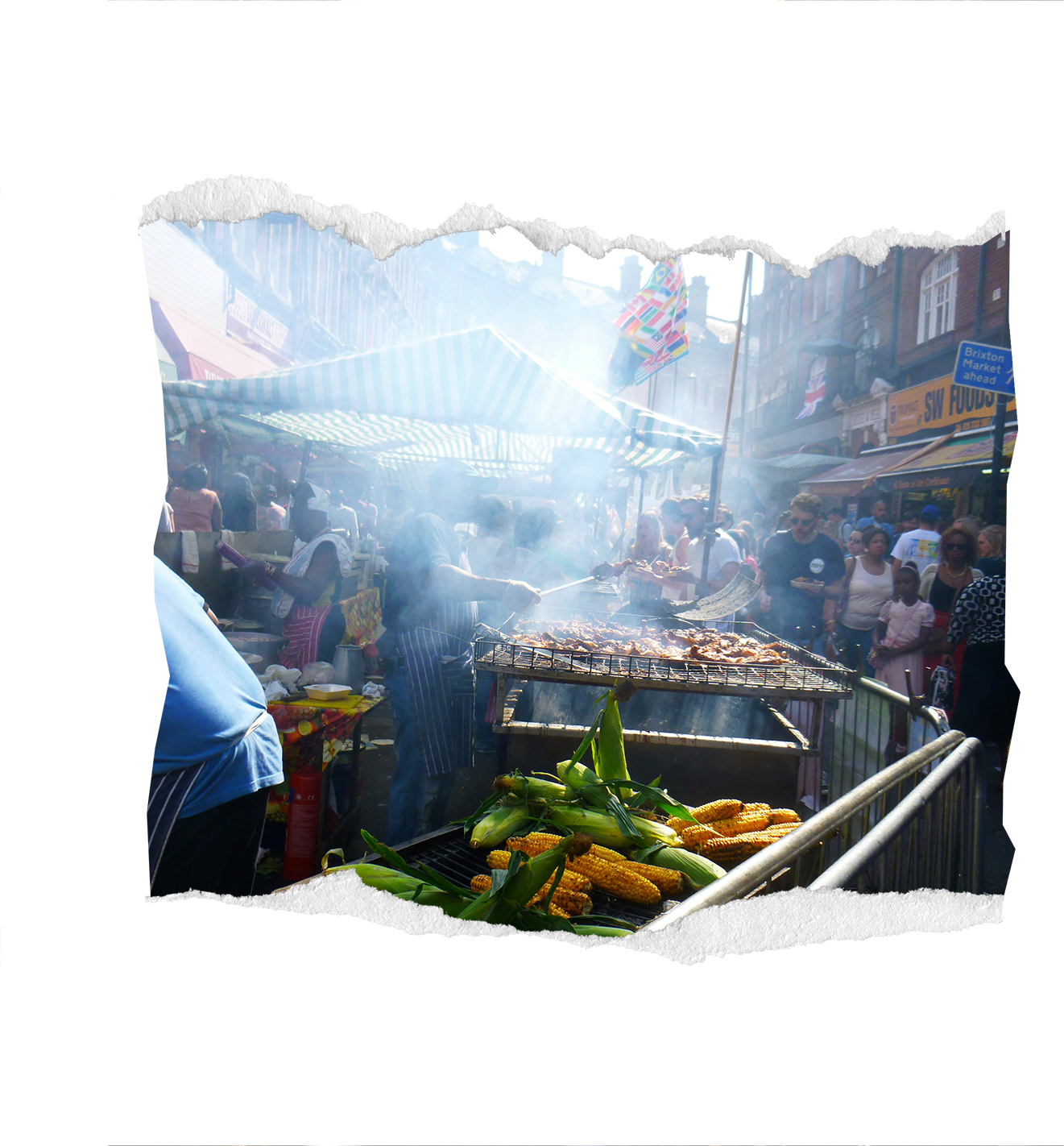 Street market with food stalls, people grilling meat, and fresh corn on the cob on display.