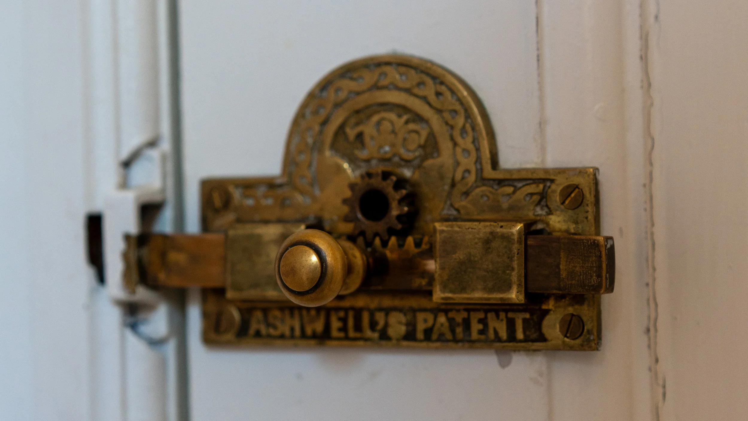 Close-up of a vintage mechanical patent date stamp with intricate metalwork and a brass button.