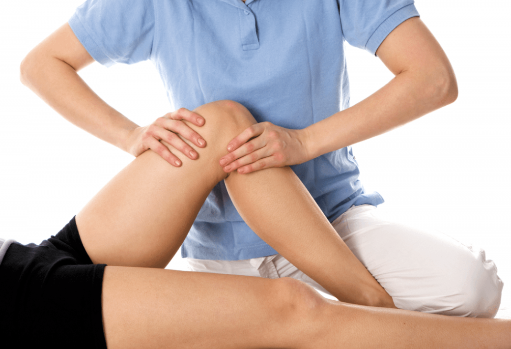 A person receiving a physical therapy or massage on their knee from a therapist.