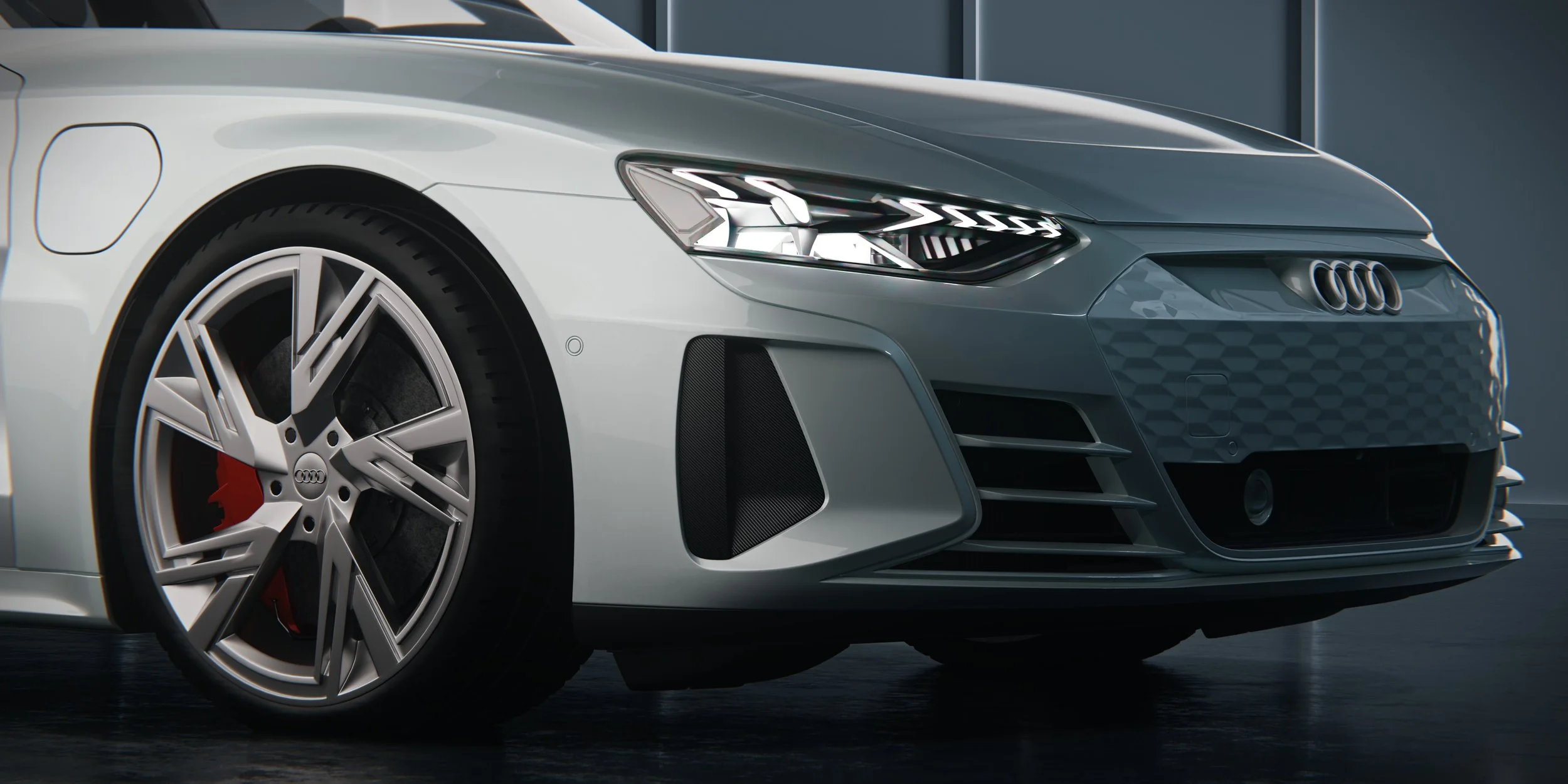 Nahaufnahme der Front eines silbernen Audi e-tron GT mit LED-Scheinwerfer, Kühlergrill und Vorderrad. Close-up of a silver Audi e-tron GT showing the LED headlight, front grille and front wheel.