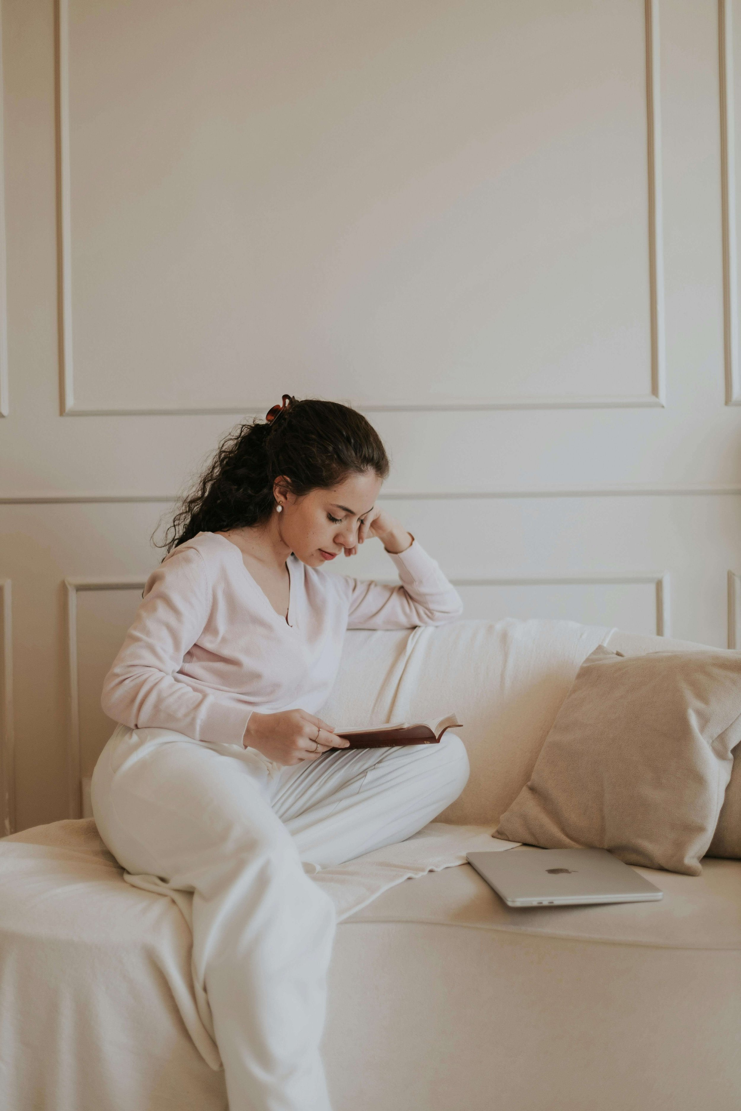 A young new mother reading a book while masshealth doula cares for her newborn in massachusetts