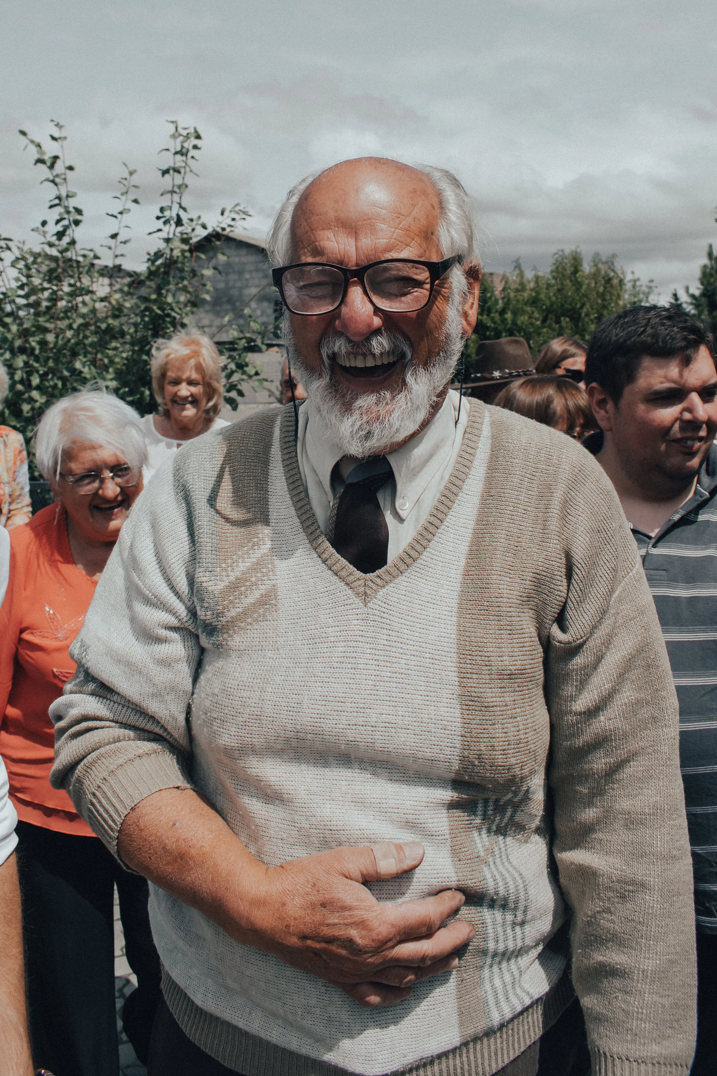 Older man smiling while spending time with family and friends.
