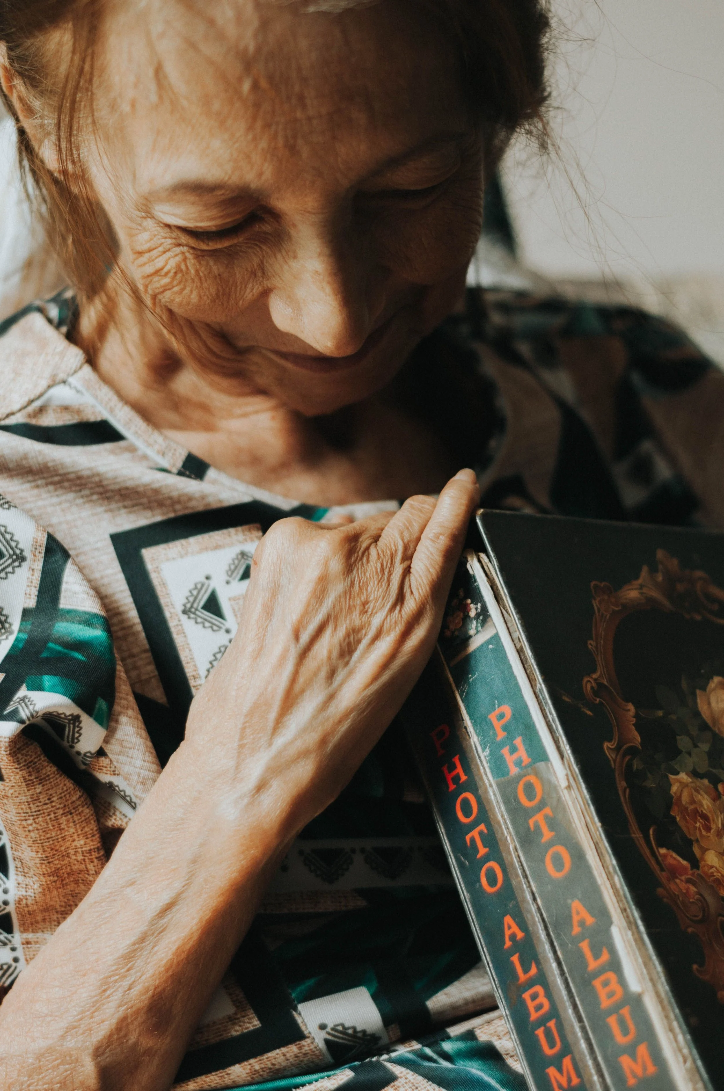 Older woman holding a treasured family photo album.