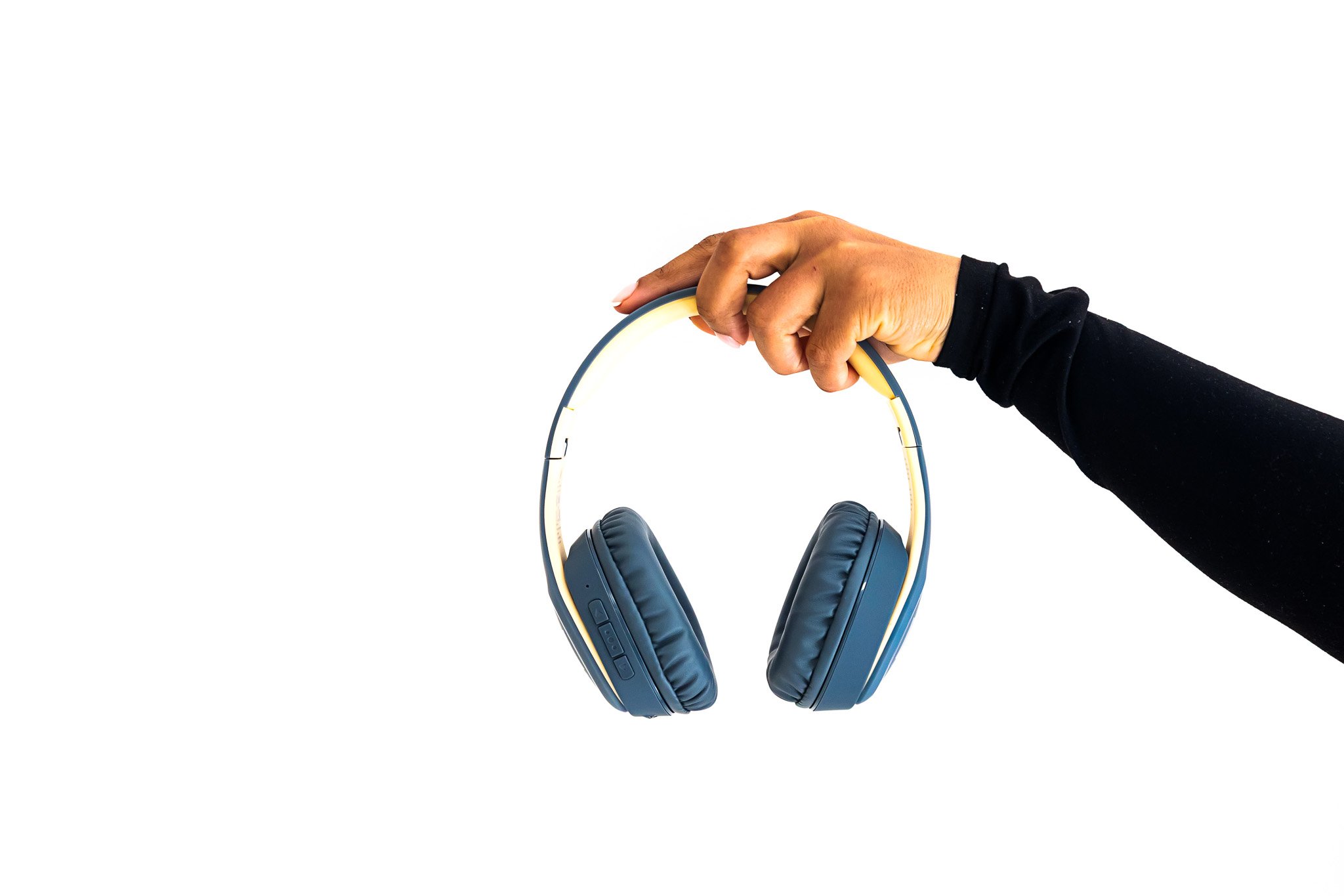 A hand holding a pair of blue over-ear headphones against a white background.