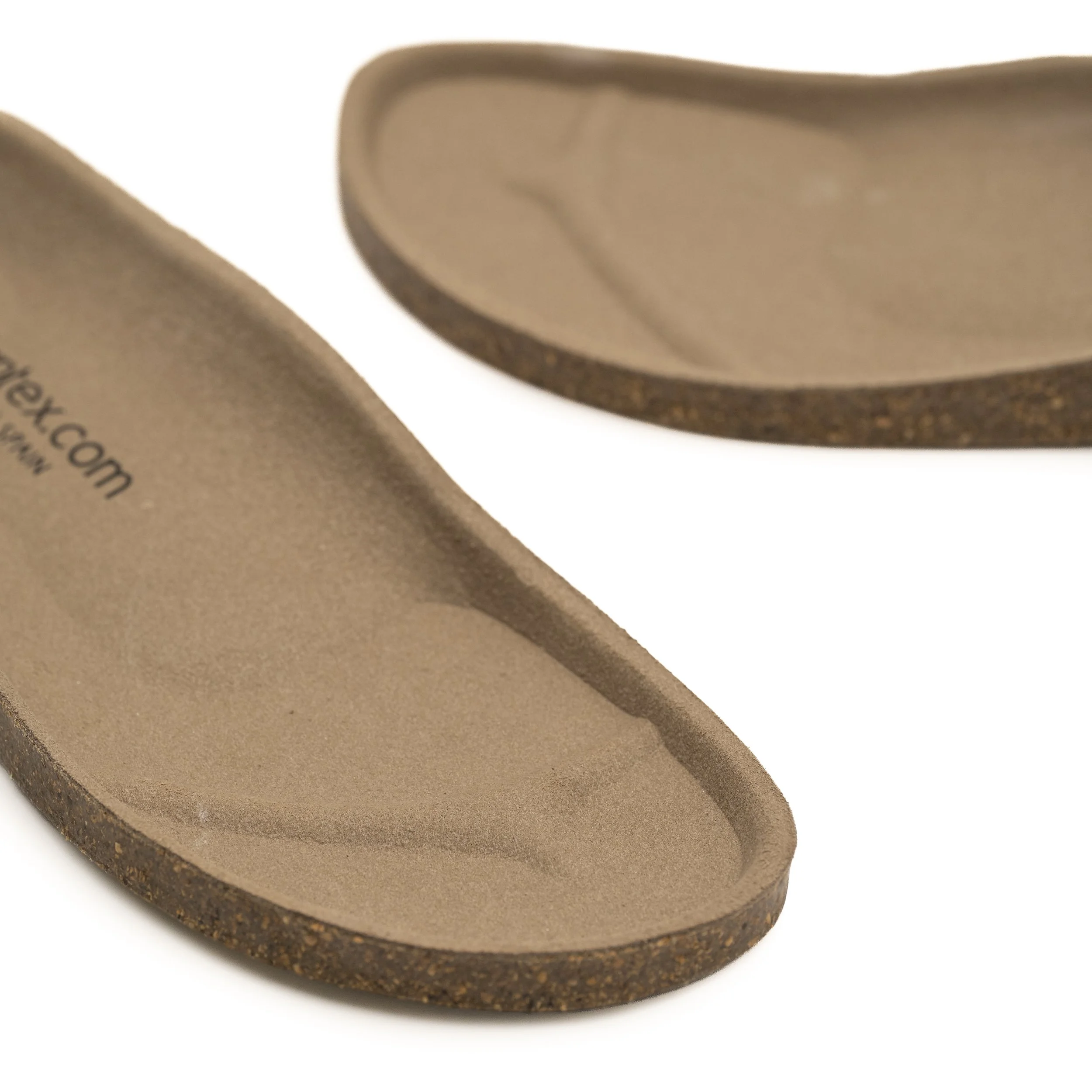 Primer plano de una plantilla de zapato de color marrón claro, con detalles de la suela y borde visible.
