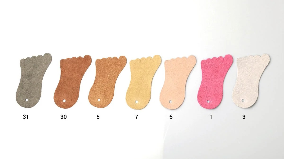 Muestras de tela en diferentes colores ordenadas en una fila, con números debajo de cada muestra, sobre fondo claro.