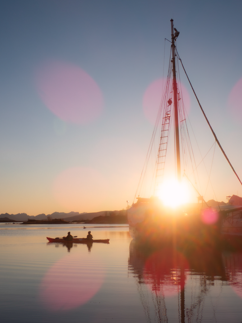 Kayakers on smooth water in golden autumn light