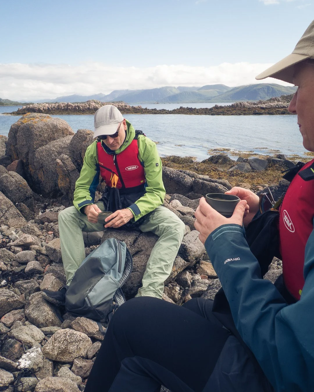 People taking a break from kayaking and enjoying a coffee on a remote coast