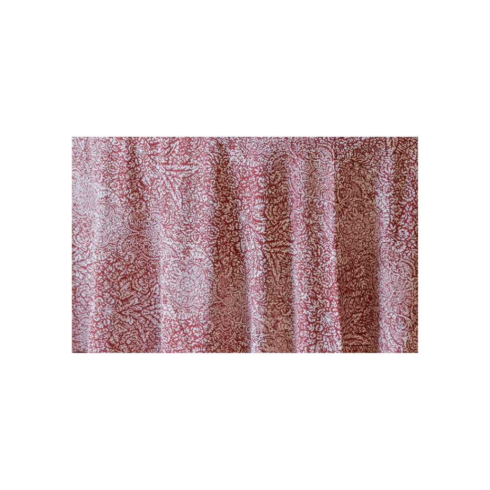 Close-up of a red and white patterned fabric with floral and intricate designs.
