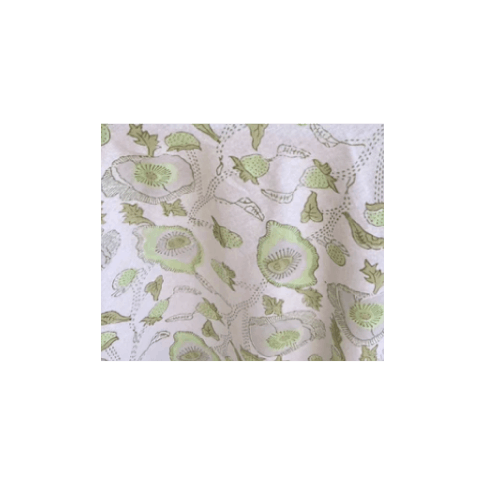 Close-up of light-colored fabric with a green floral pattern.