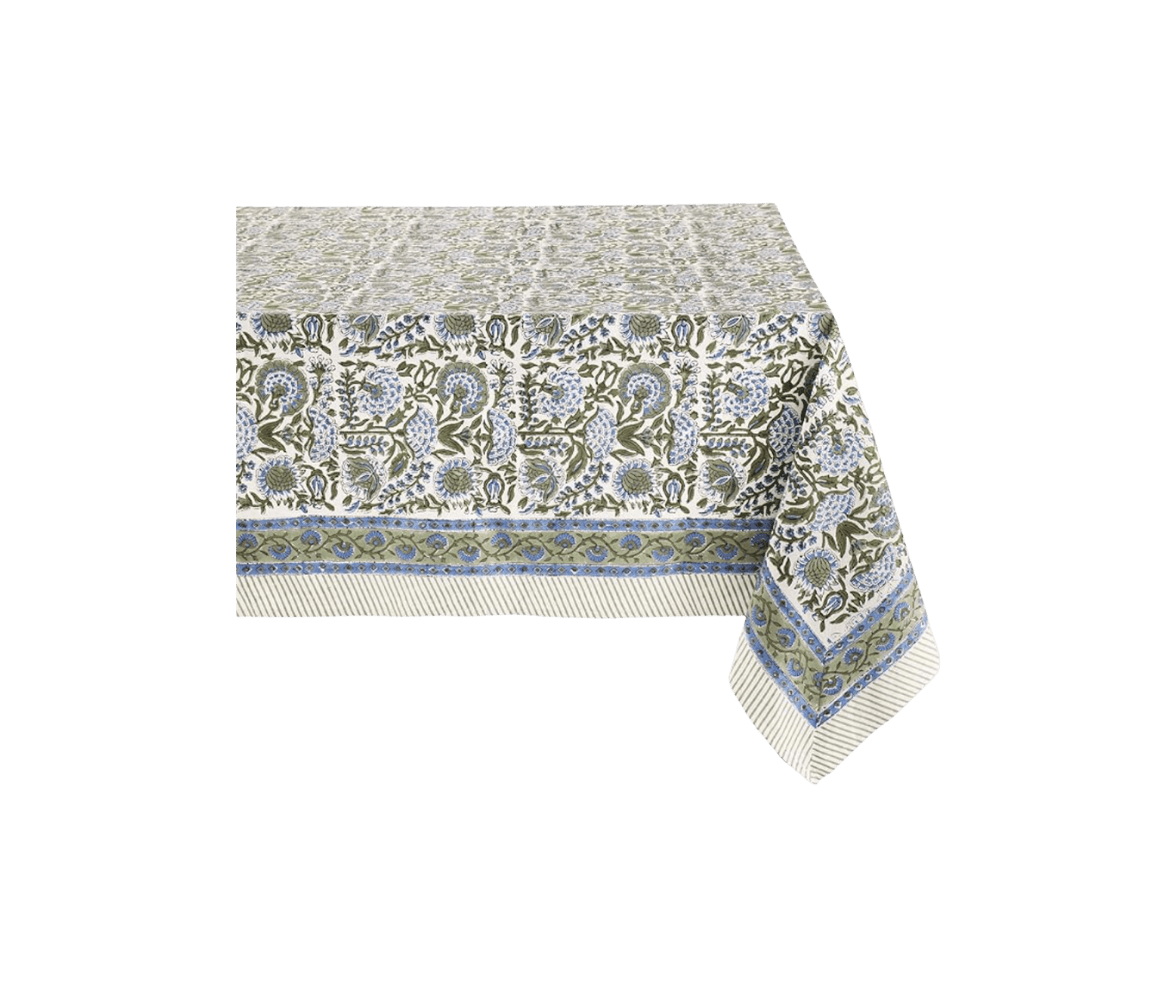 A rectangular table covered with a floral-patterned tablecloth featuring blue and green flowers and leaves on a white background.