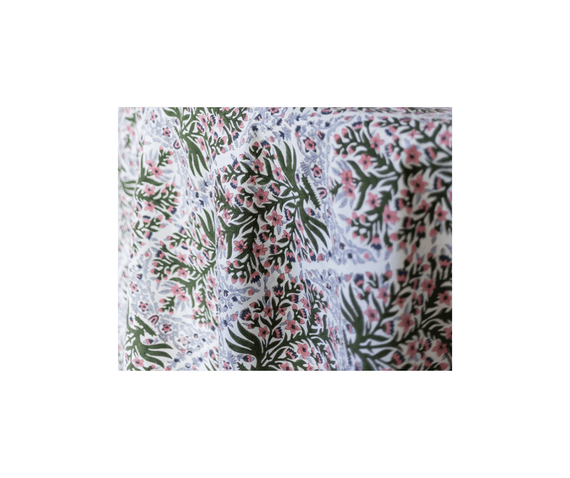 Close-up of floral patterned fabric with green leaves and pink flowers.