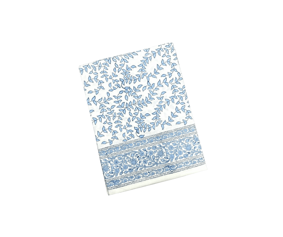 White kitchen towel with a blue vine and leaf pattern and a decorative blue border at the bottom.