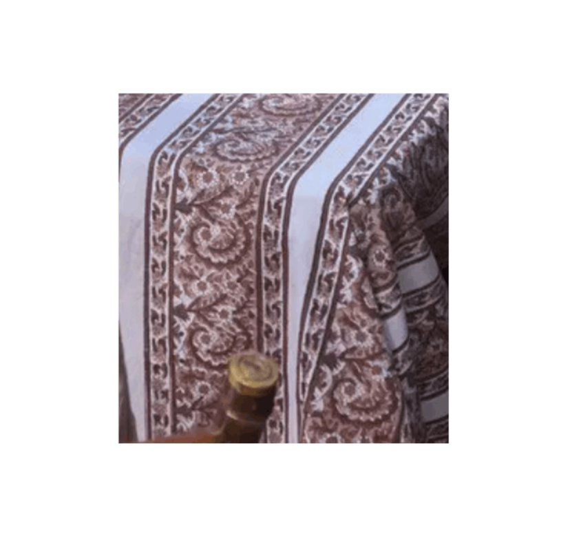 Close-up of a patterned tablecloth with a bowl or container at the bottom of the image.