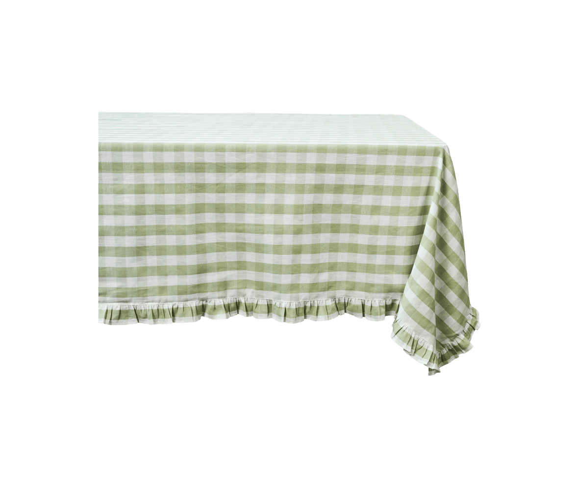 Green and white checkered tablecloth with ruffled edges draped over a table.