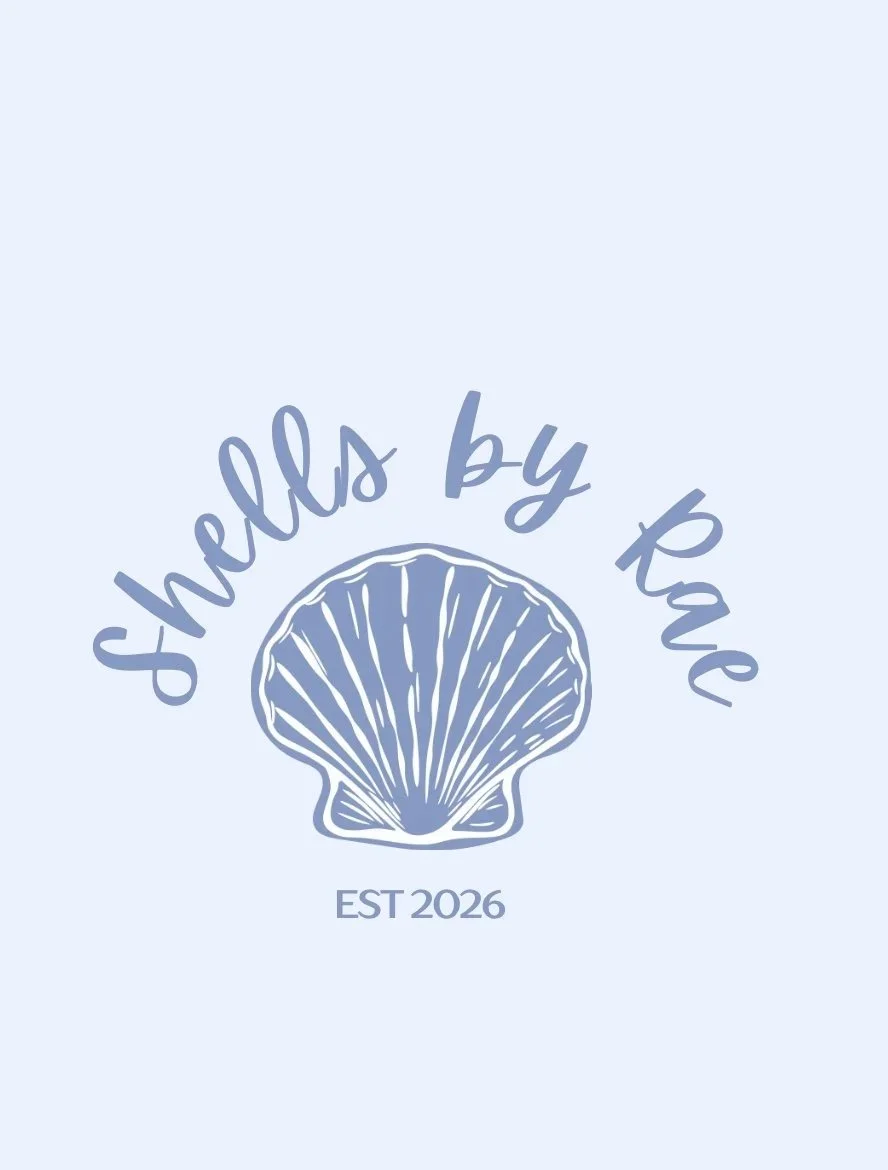 A light blue background with a line drawing of a scallop shell in the center. Around the shell, the text reads "Shells by Kate" in cursive. Below, it says "EST 2026" in uppercase letters.