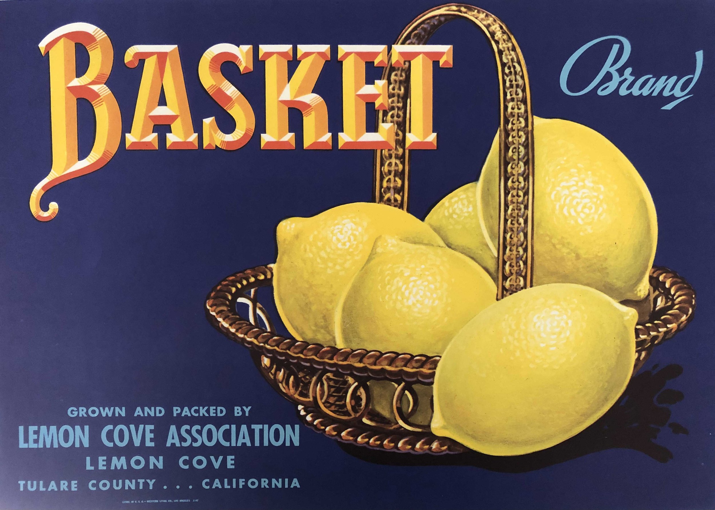 Colorful vintage-style sign for Lemon Cove Lemon Cove Association, featuring a basket filled with ripe lemons and the word 'BASKET' prominently displayed.