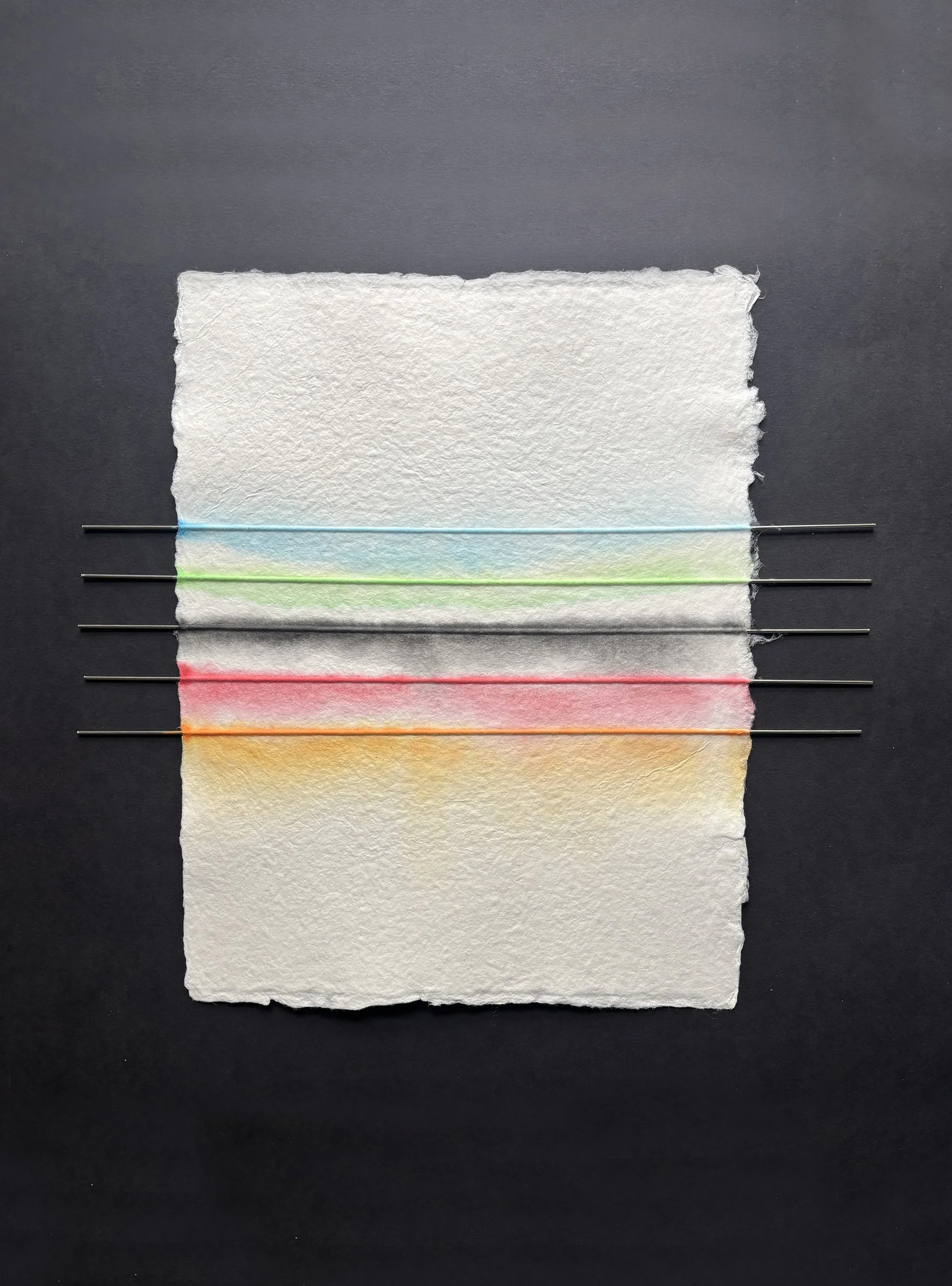 Stainless steel rods encased in hand made paper with lines of acrylic paint.