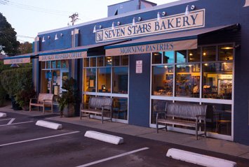Exterior of Seven Stars Bakery with benches and parking in front.