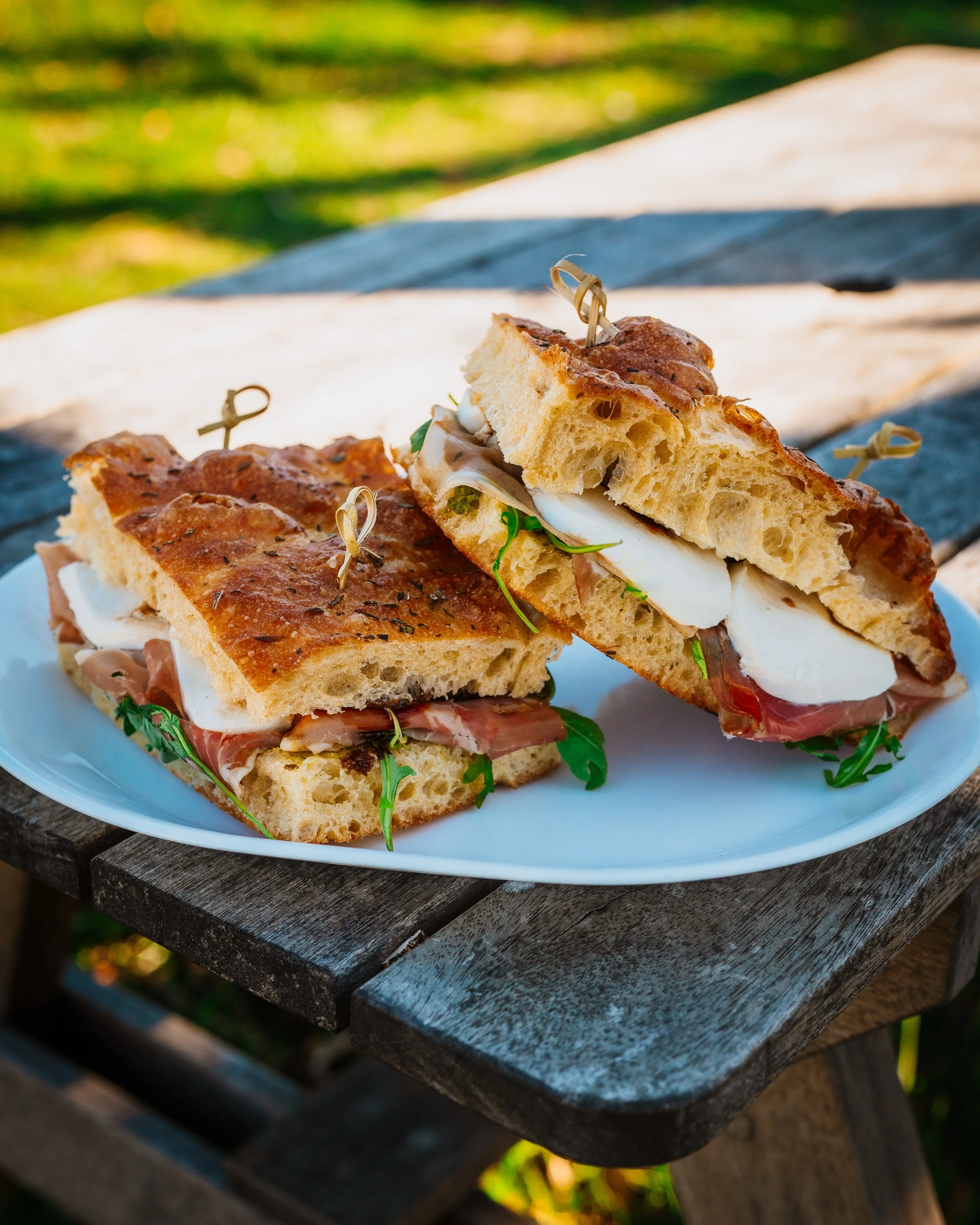 Seven Stars Bakery sandwich with proscuitto, cheese and greens, served outdoors.
