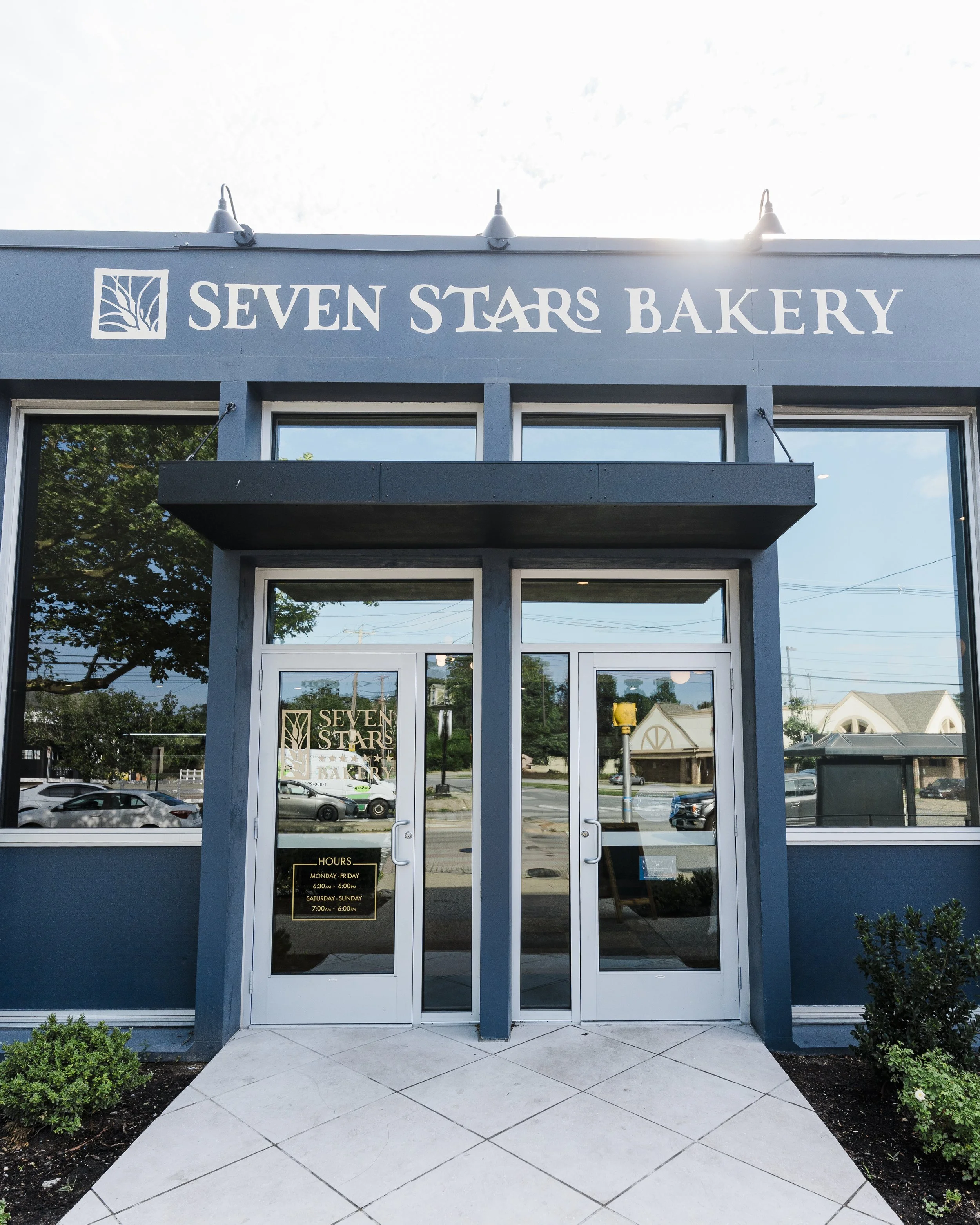 Front entrance of Seven Stars Bakery Edgewood Cranston cafe with glass doors and the logo above.
