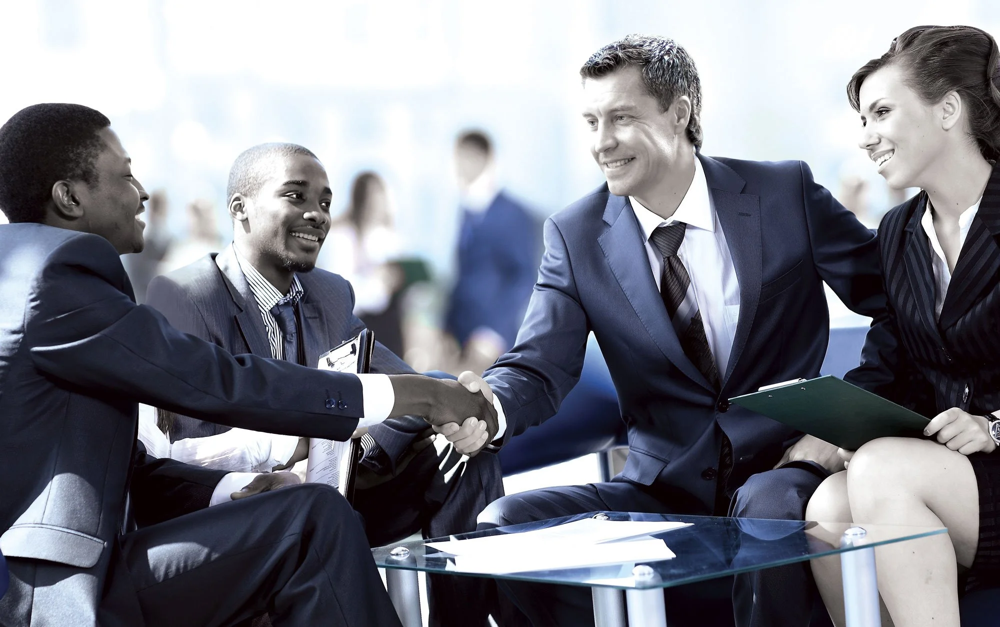 Business professionals shaking hands during a life insurance planning discussion.