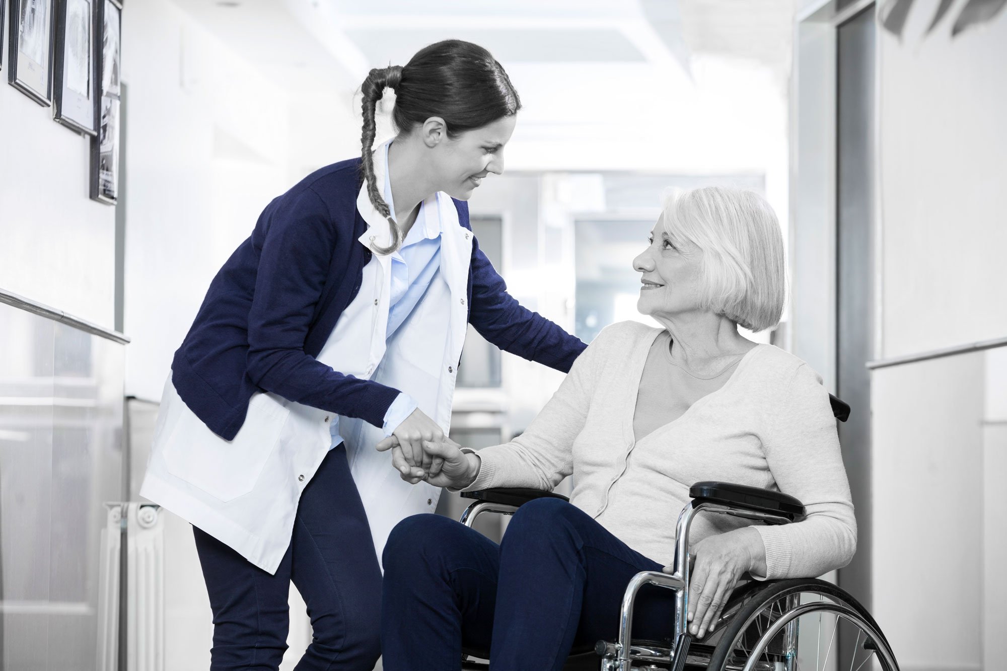 Caregiver assisting an older adult in a wheelchair for long-term care planning.