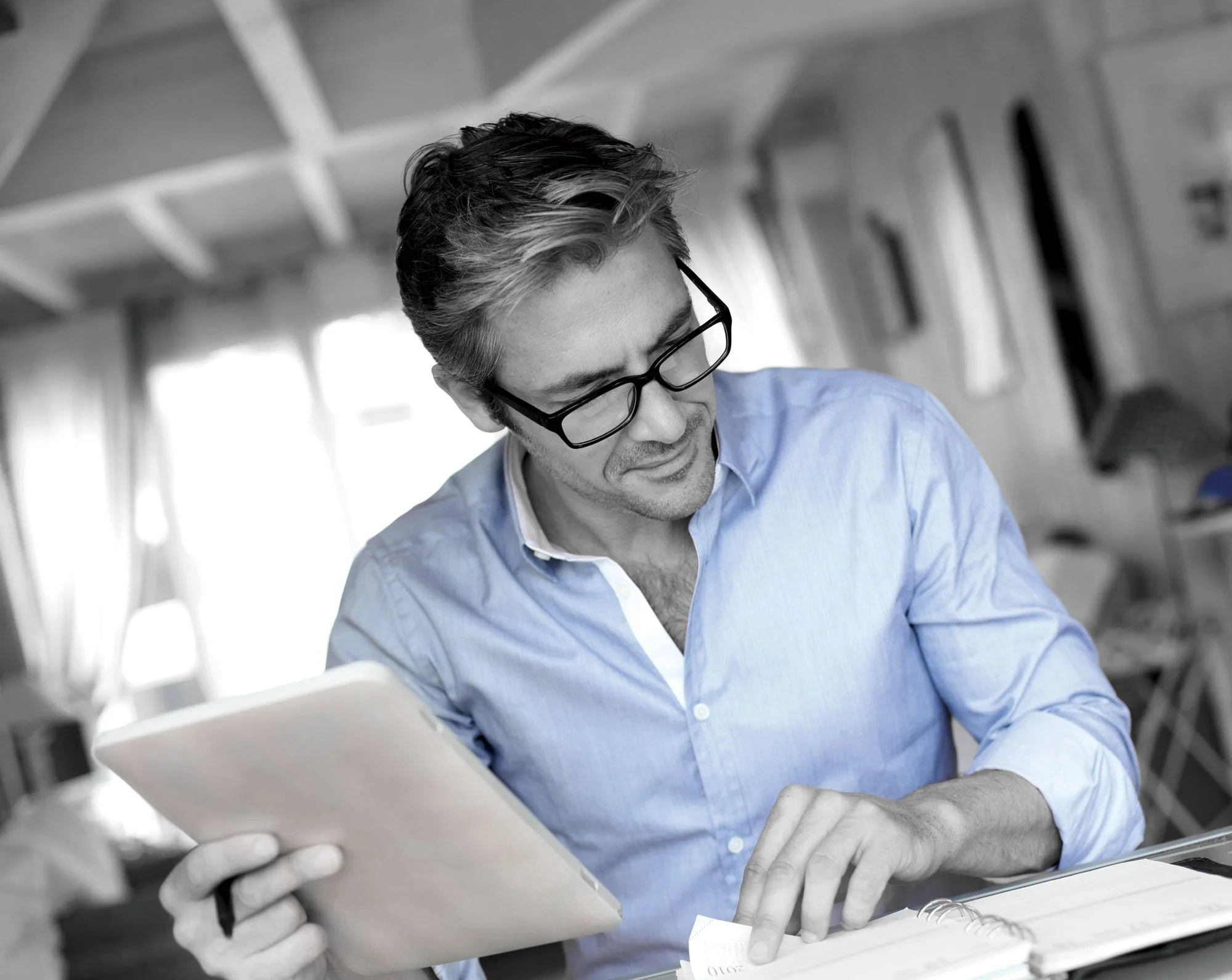 Man reviewing financial documents during a certified divorce financial analysis.
